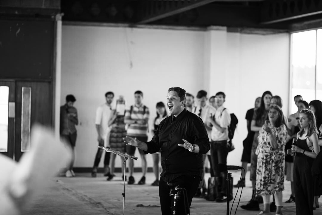 Guest conducting London Metropolitan University's Musarc Choir in Benjamin Tassie 's 'Silvertown' at the old Carlsberg & Tetley's Factory in Silvertown , London (UK); June 2017