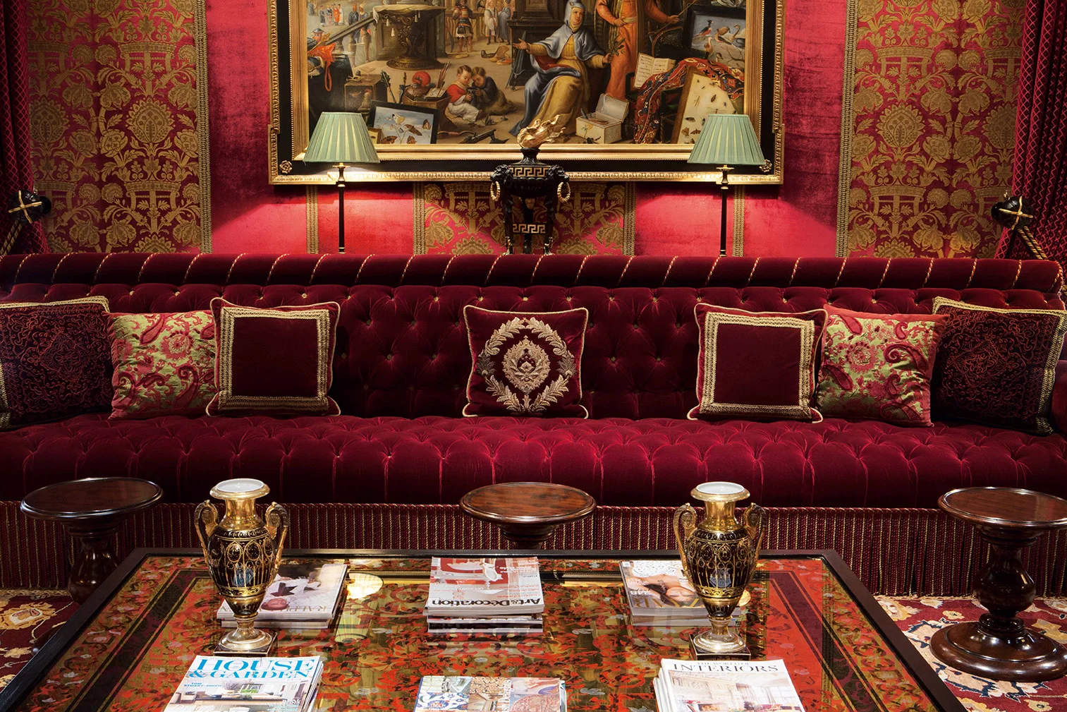 There is a combination of embossed and plain fabric wallpapers, and each stripe section is defined by a gold braid trim. The highly decorative background is balanced by this relatively plain red velvet sofa. It is a bespoke piece minutely detailed to my exact specifications so as to work with the surrounding textures, colours and patterns. The coffee table is inspired by 17th century boulle work but made in verre eglomise that cleverly imitates inlaid brass in tortoiseshell.