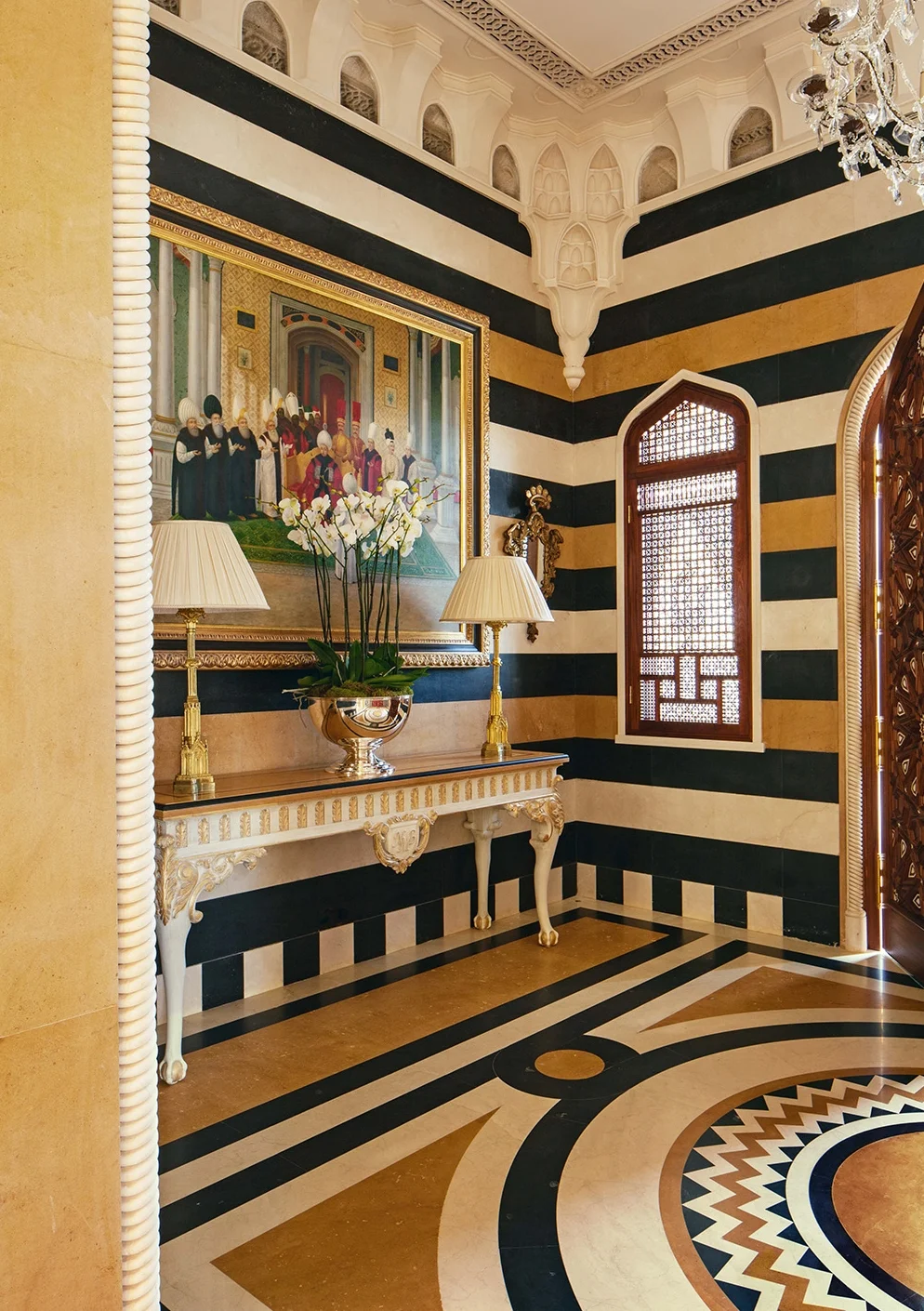 The up-scaled classical design in the marble floor increases the sense of grandeur and space. The fine detail on the paneled doors shown are very much part of the classical scheme throughout this home. Each panel has been hand-painted on canvas before being applied to the door. Wherever I can I will specify water gilding for moldings so I can acheive the right gold look.