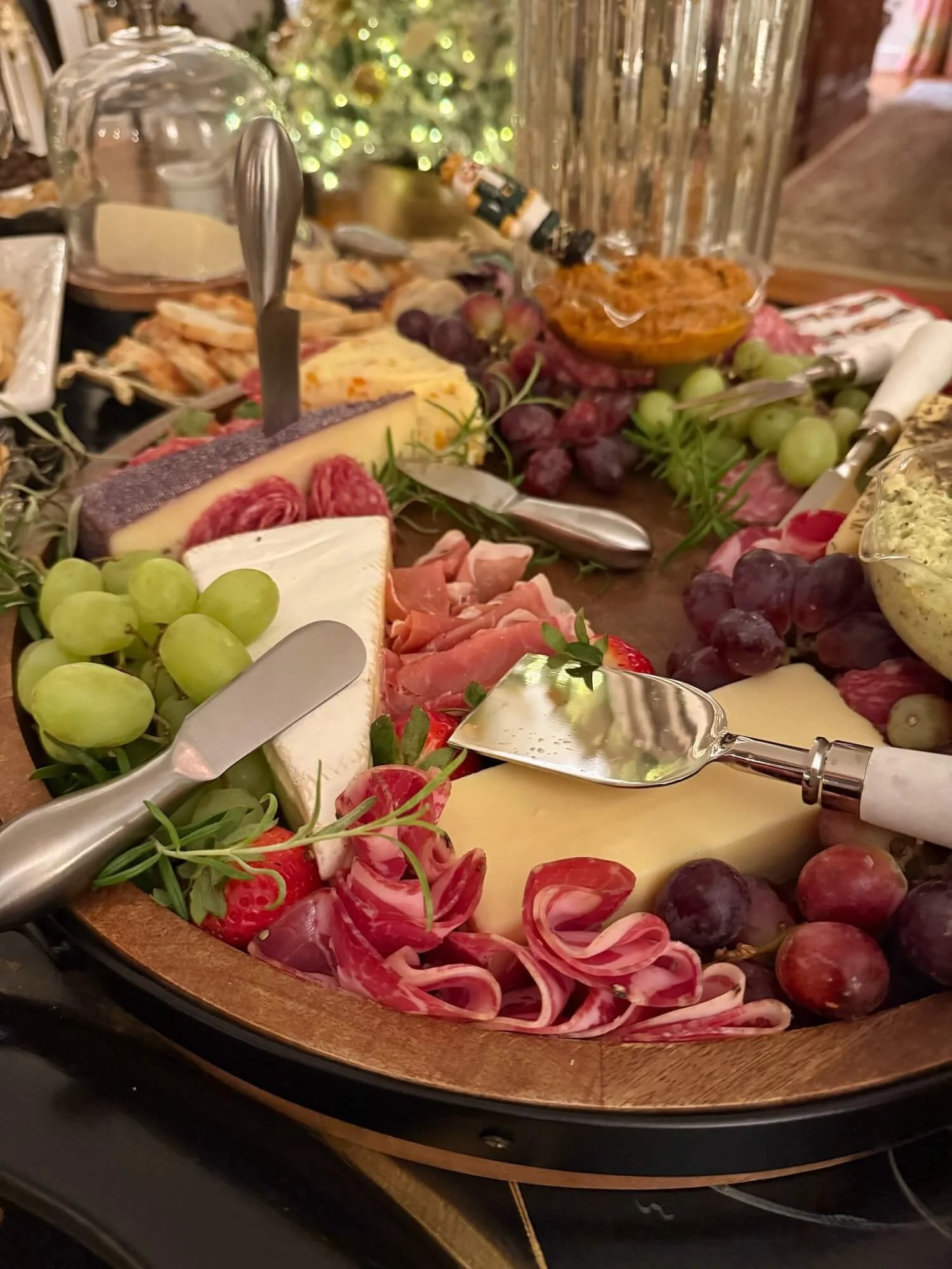 cheese and charcuterie arranged on a round wooden tray