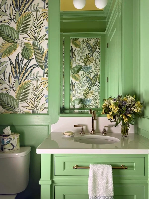 green powder room with wallpaper and paneling