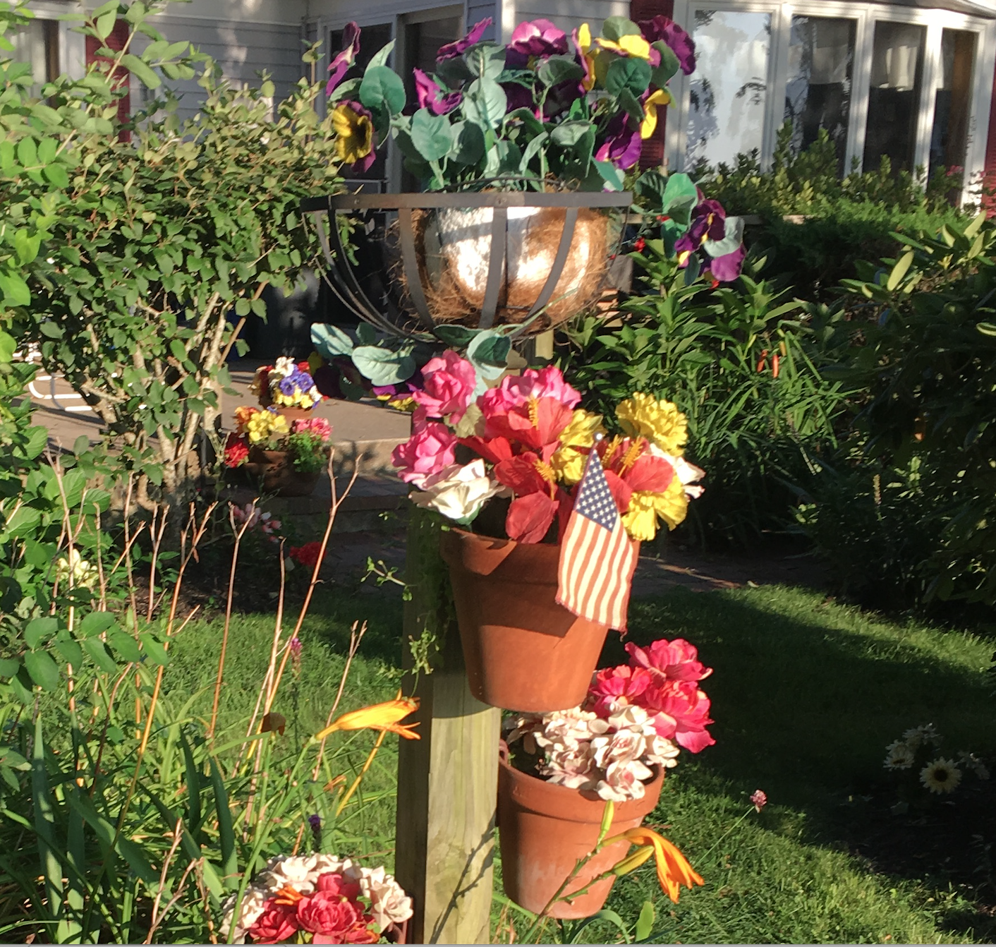 To be clear, I am NOT advocating adding cheap plastic flowers to your yard (like this decorative post where dusty relics apparently go to die at this oceanfront cottage!)