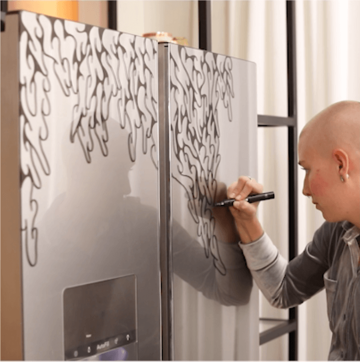 artist decorating the cafe glass refrigerator.png
