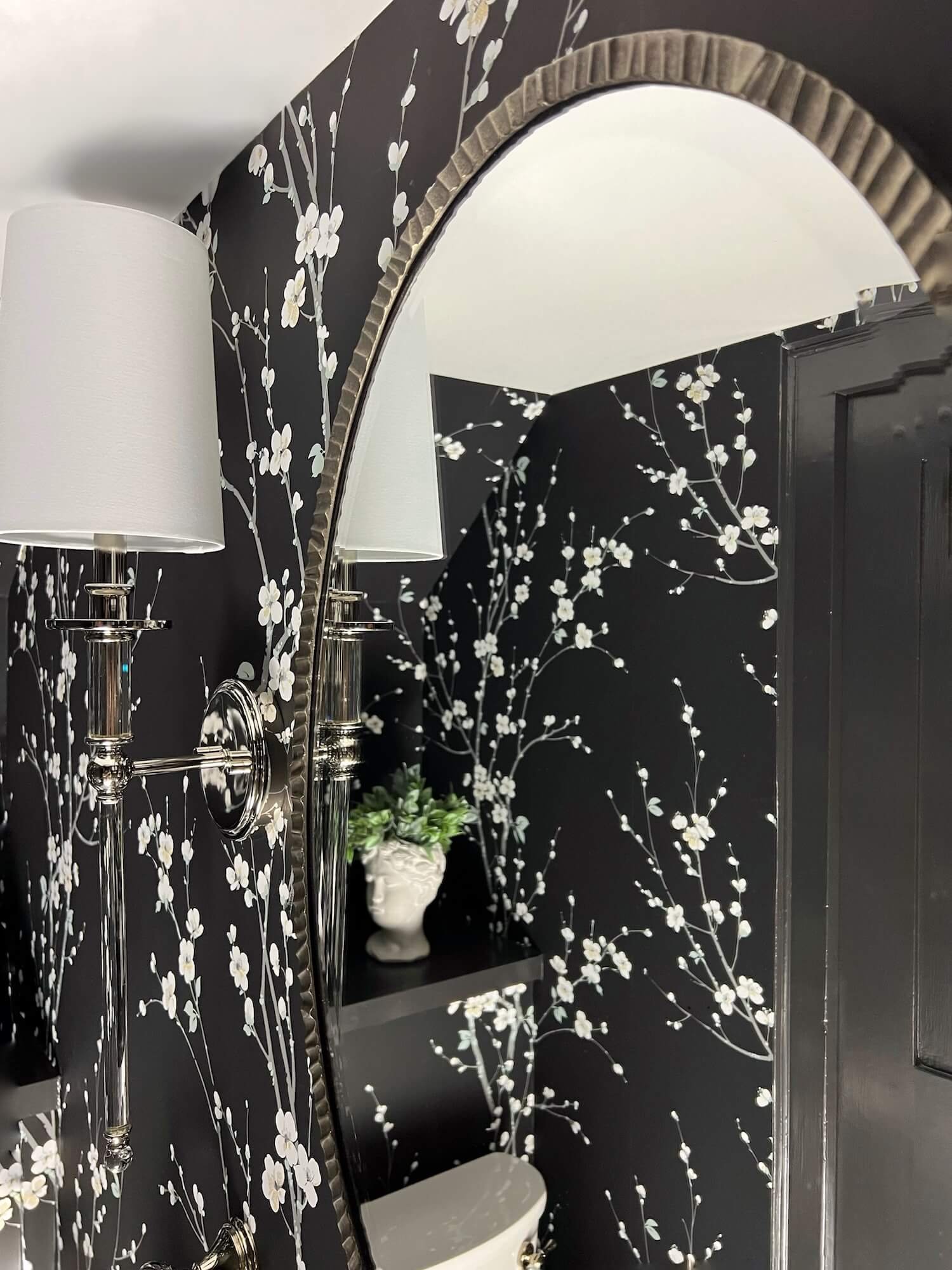 glossy black millwork and a silver framed mirror finish the space