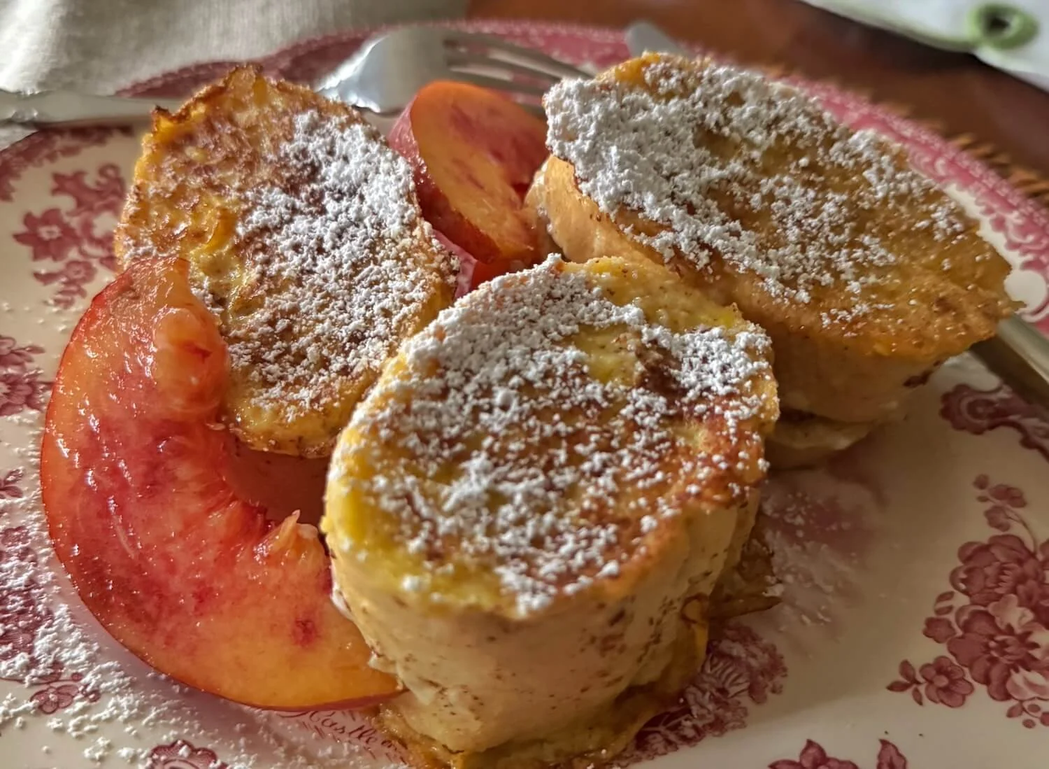 peach stuffed french toast dusted with powdered sugar and garnished with peach slices