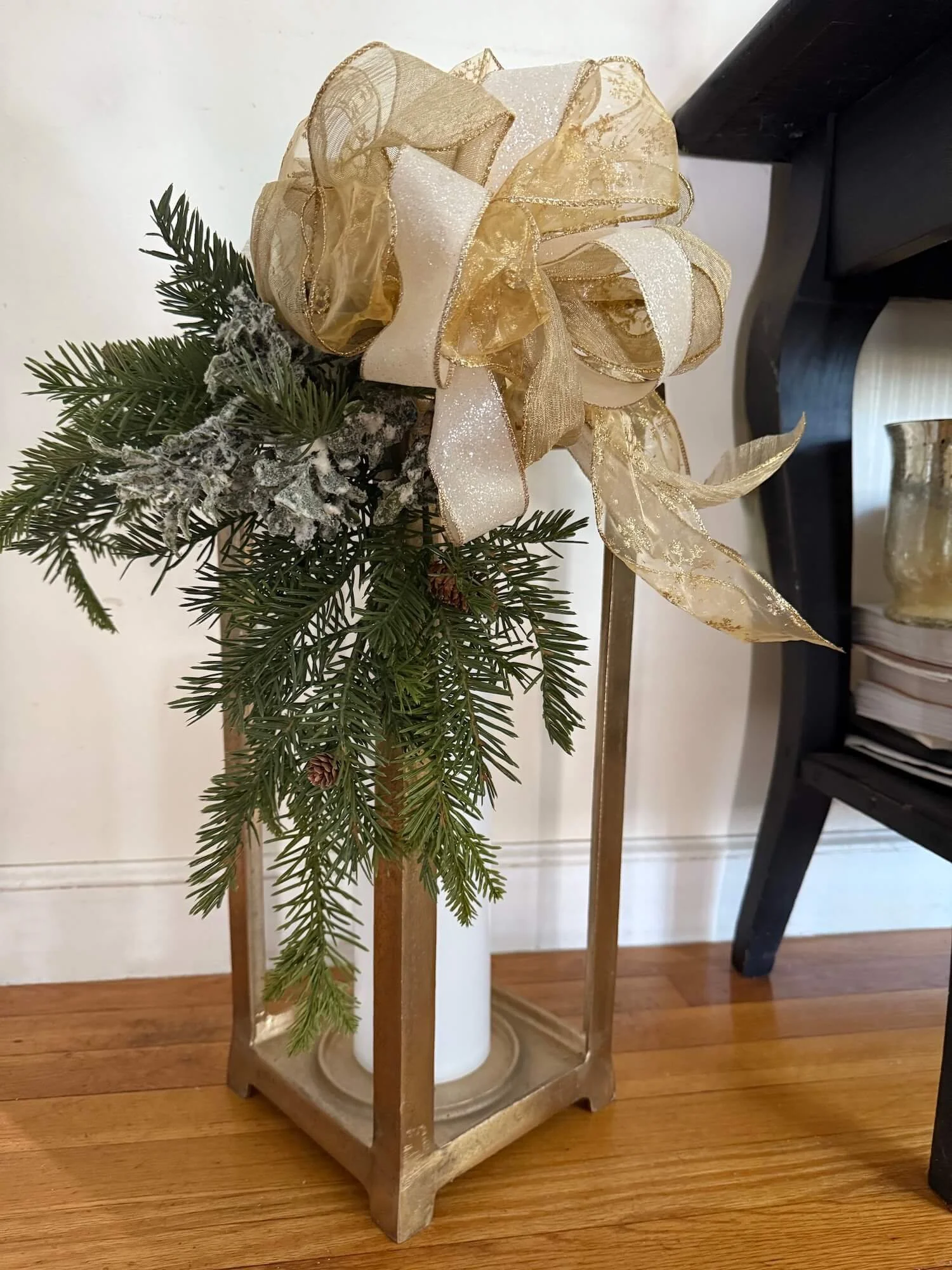 lantern decorated with winter greens and ribbons