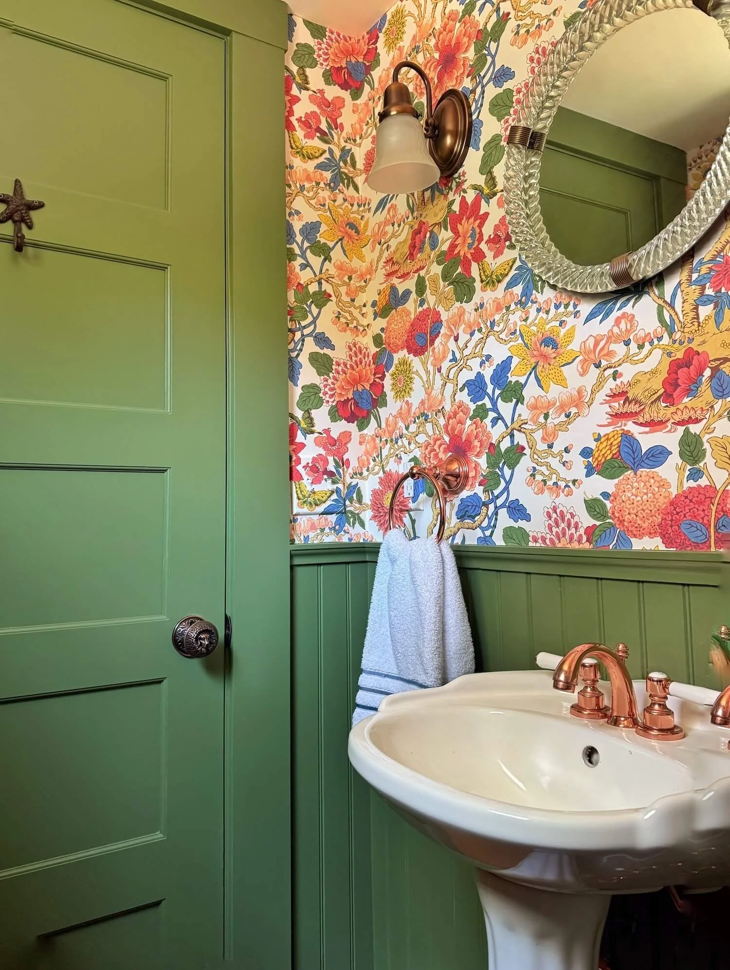 powder room with colorful paper and green painted woodwork
