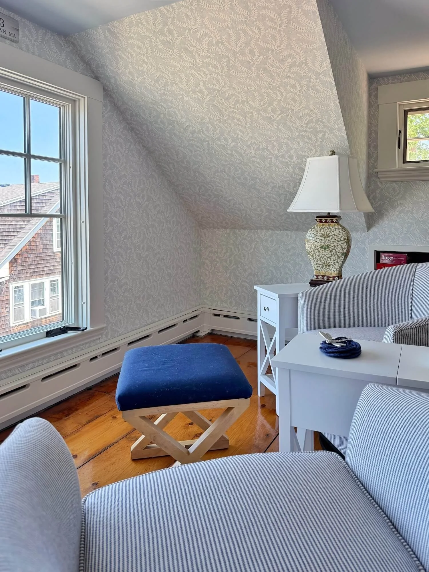 attic room tub chairs and wallpapered walls
