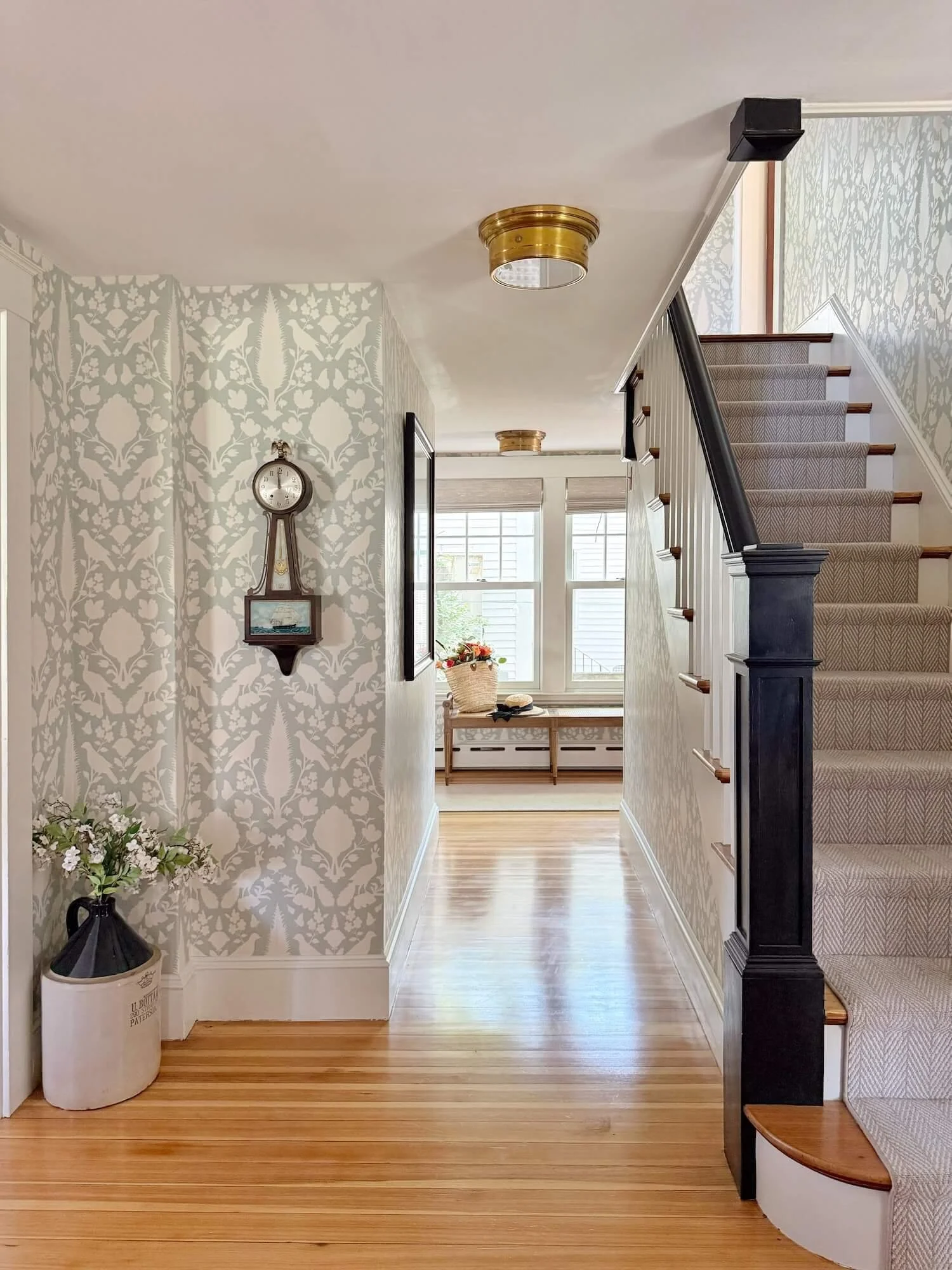 entry stairs with runner and wallpapered hall