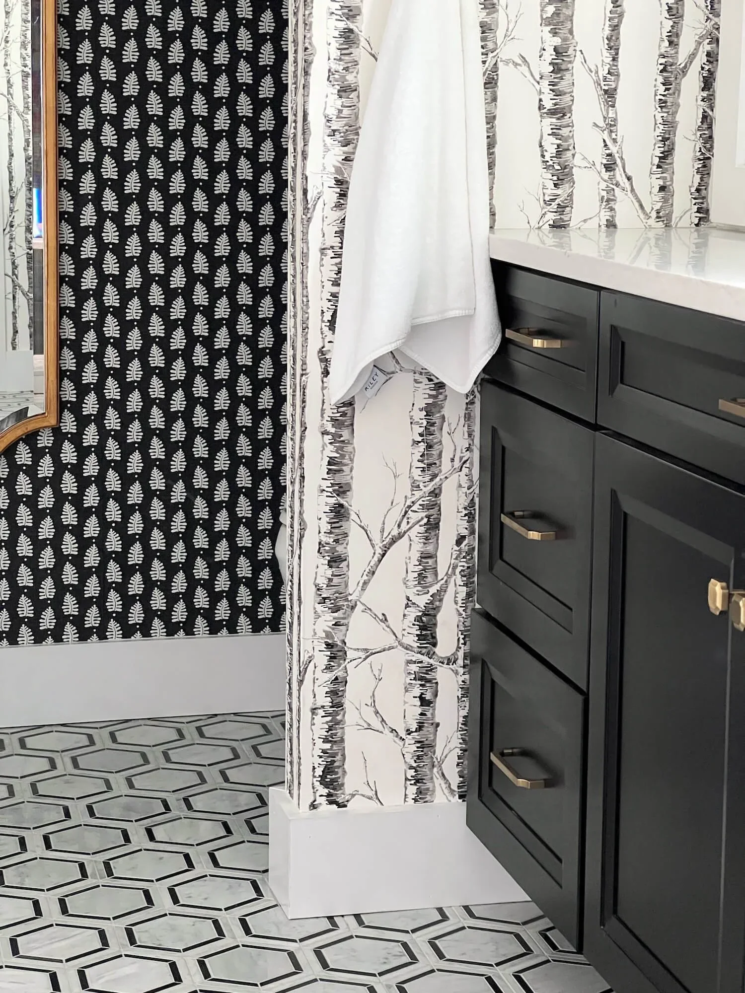 black and white wallpaper cabinetry and tile in a bathroom