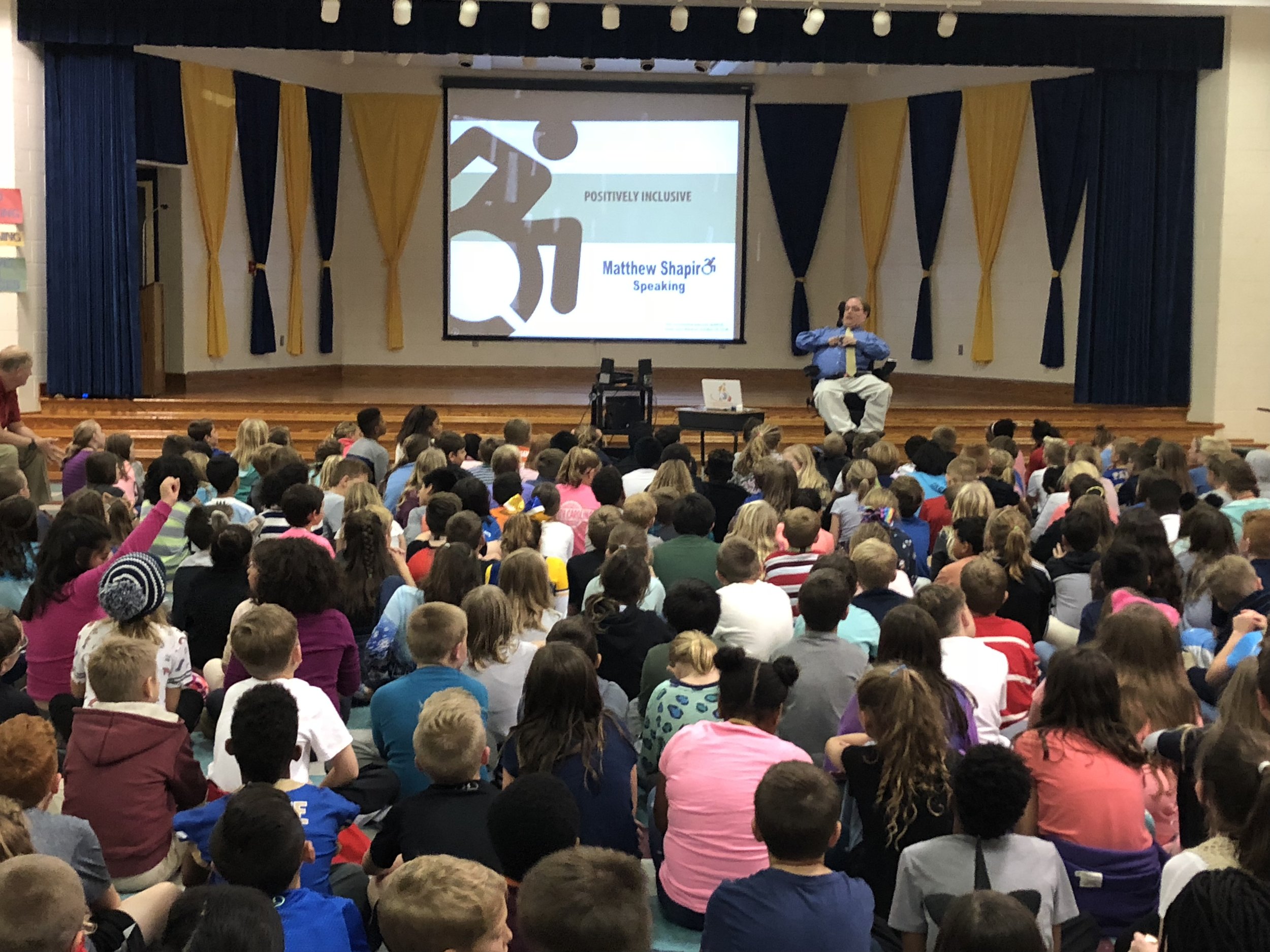 PHOTO: Matthew sitting In front of 250 fourth and fifth grade students Woolridge Elementary School during his Positively Inclusive presentation.