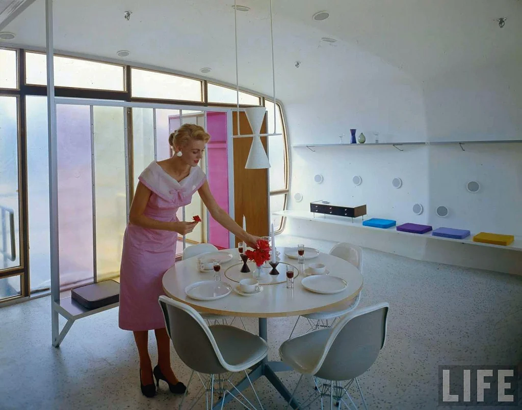 The Woman of the Future sets the table with a bouquet of plastic flowers.