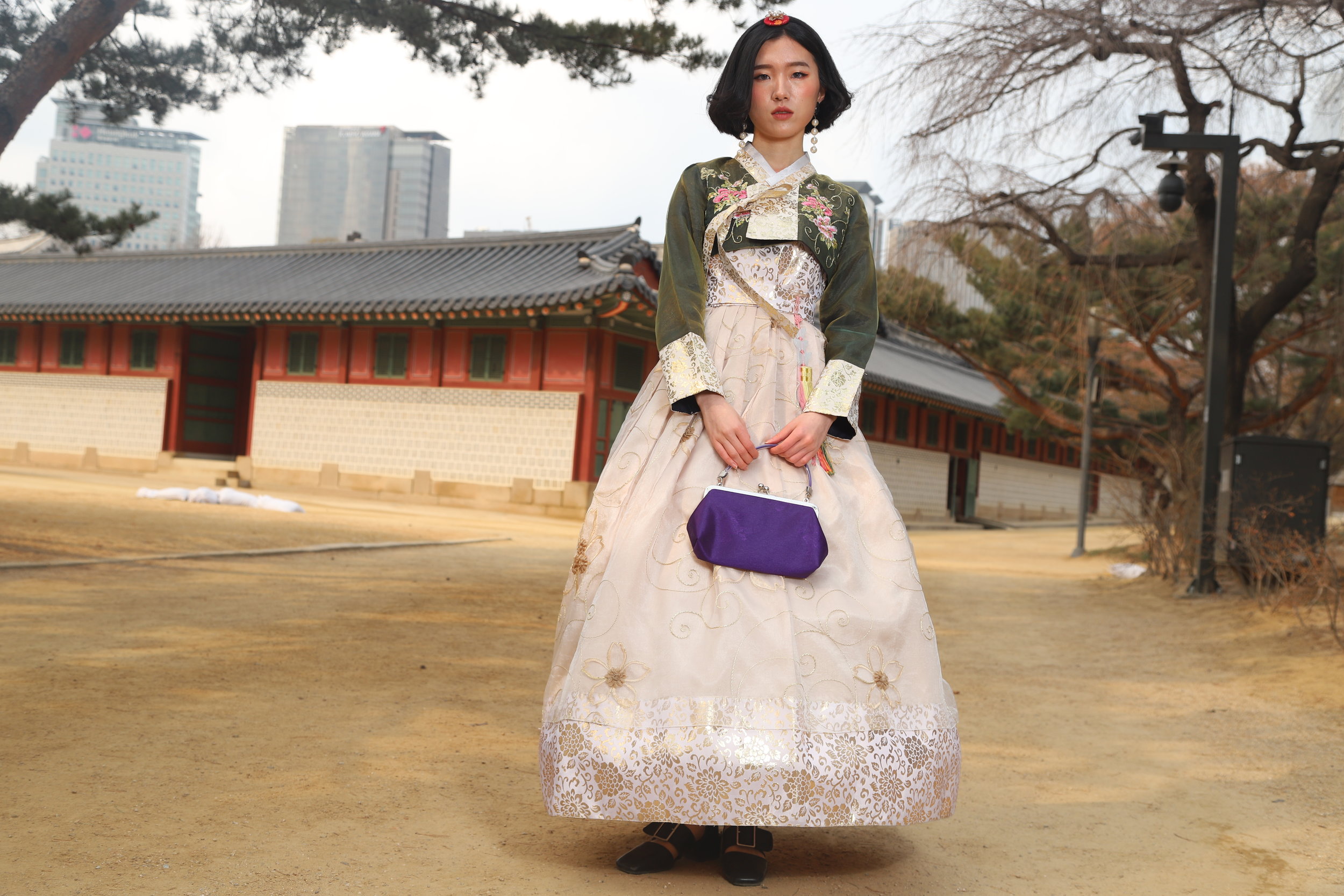 TOURIST Korea, done WRONG. Our model Jihye poses in one of the standard korean hanbok often rented out to tourists, which are considered by many actual hanbok designers an affront to the idea of the original hanbok, made as they are with hoops like found in a western-style ballroom dress and fabrics and patterns that, while pretty, are not even traditional Korean patterns or materials but rather look like those found on window drapes. 