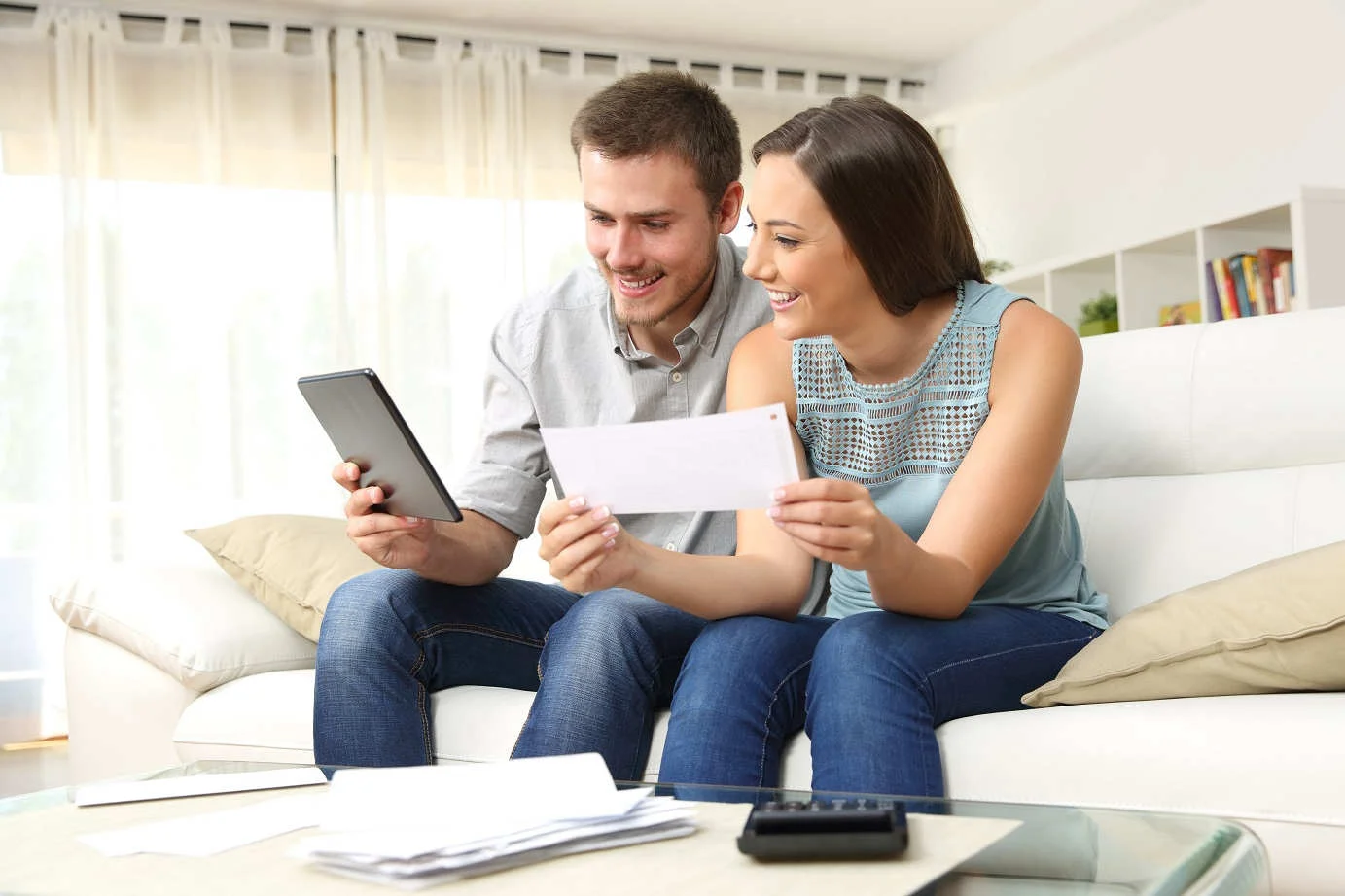 young-smiling-couple-budgeting-on-couch.jpg