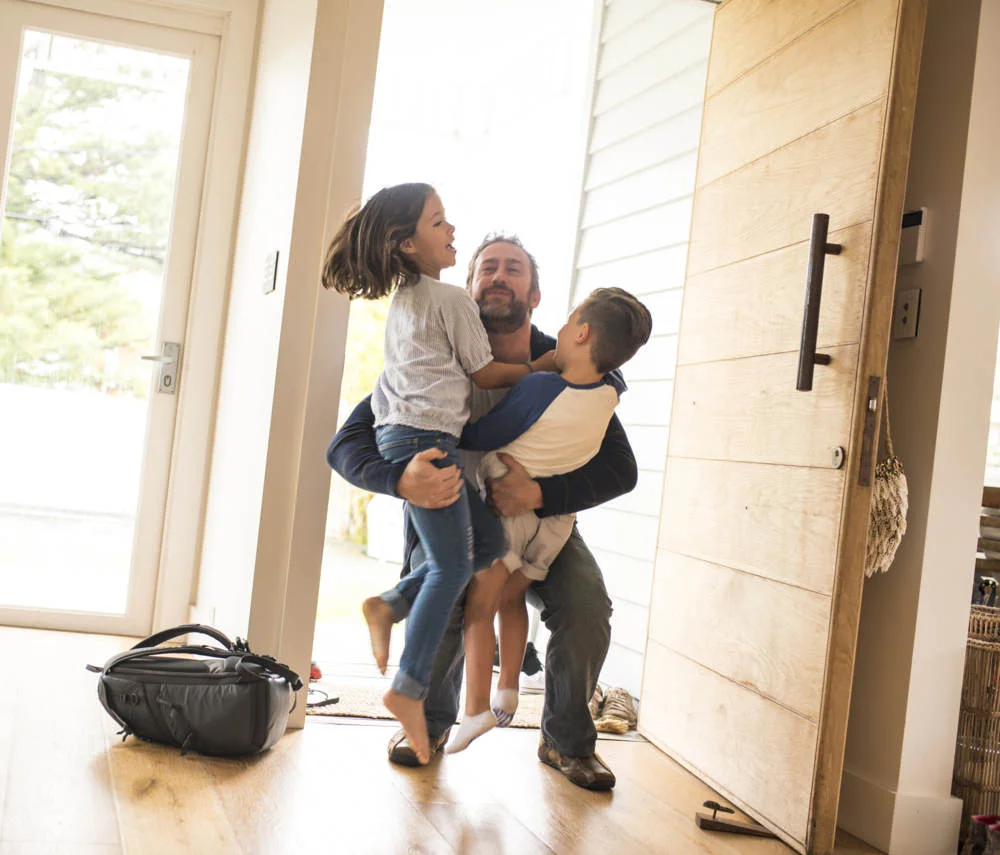 dad-and-two-kids-hugging-in-house.jpg