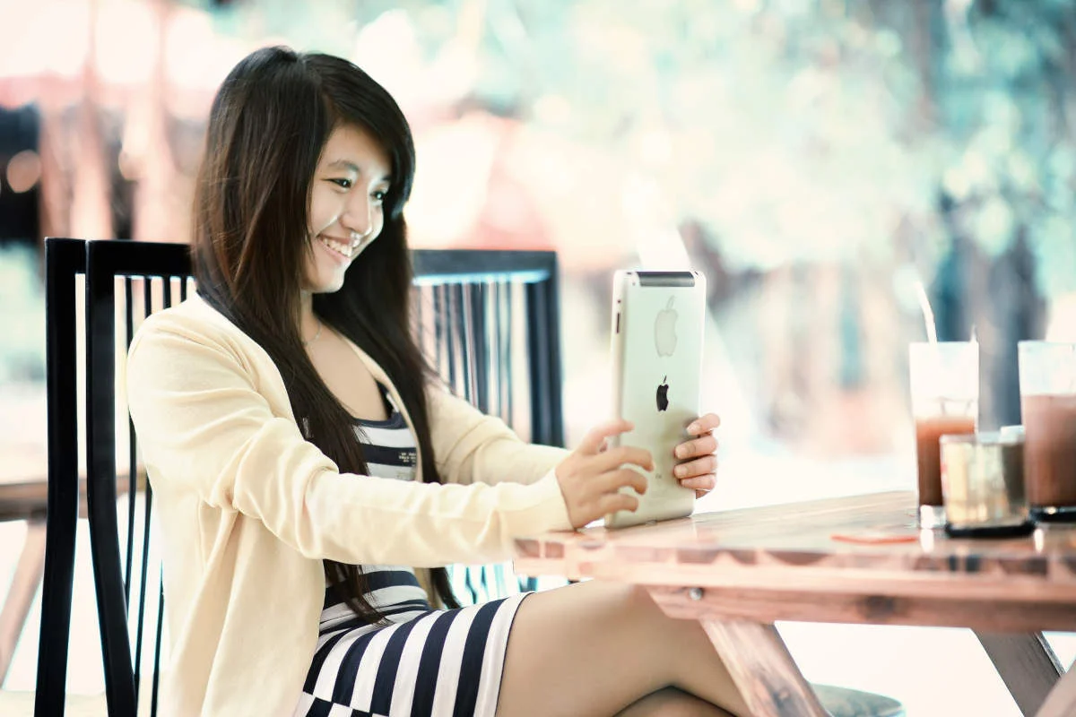 asian woman smiling at ipad.jpg