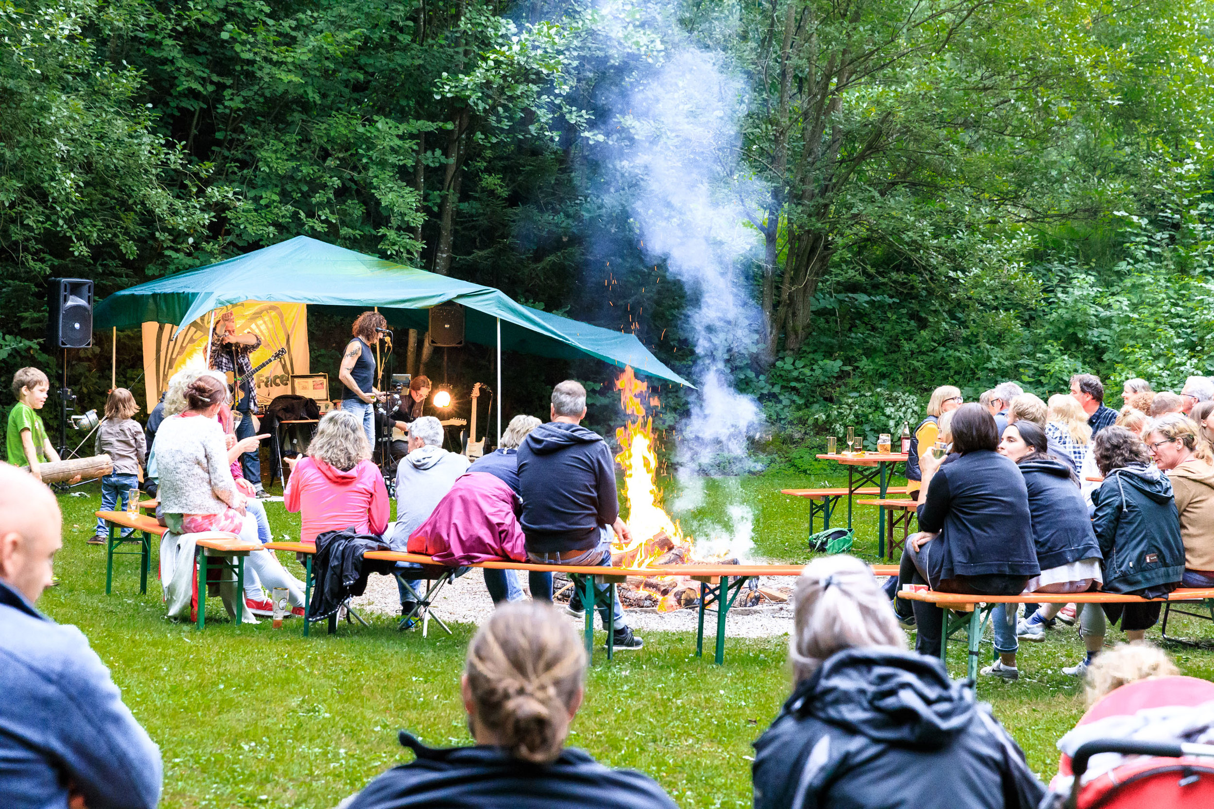 Menschen sitzen um Feuer