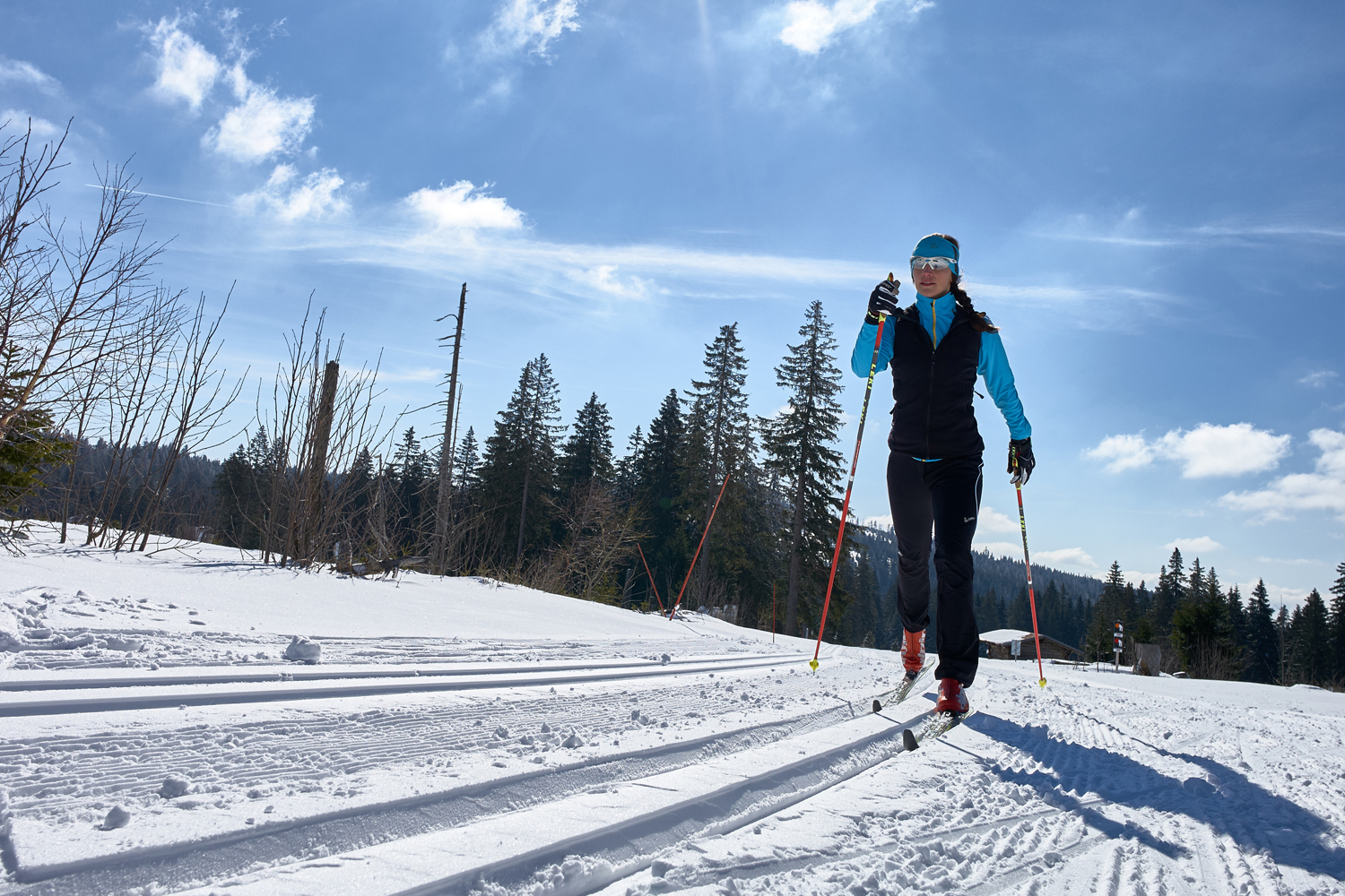 Langlaufski und Frau läuft in Loipe