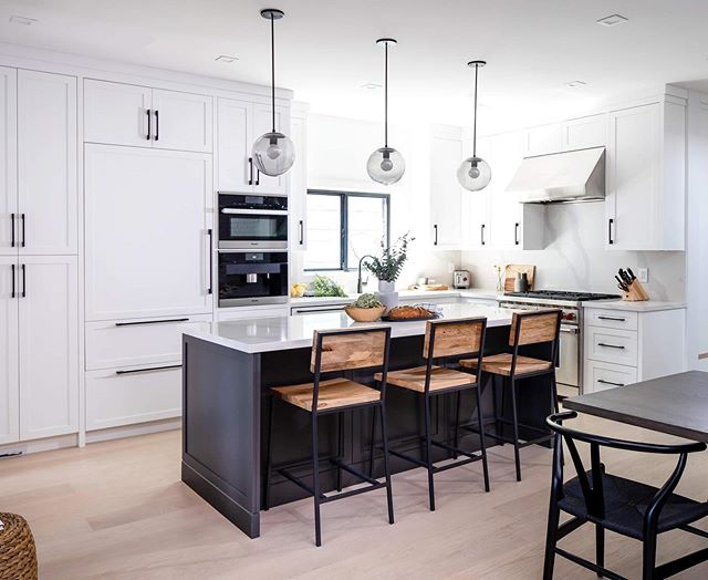 17TH AVE | We&rsquo;re so happy with how this high- contrast space came together and how the gray kitchen island with smoke glass pendants from @schoolhouse creates a unique focal point in this open-concept main floor. #md17thave