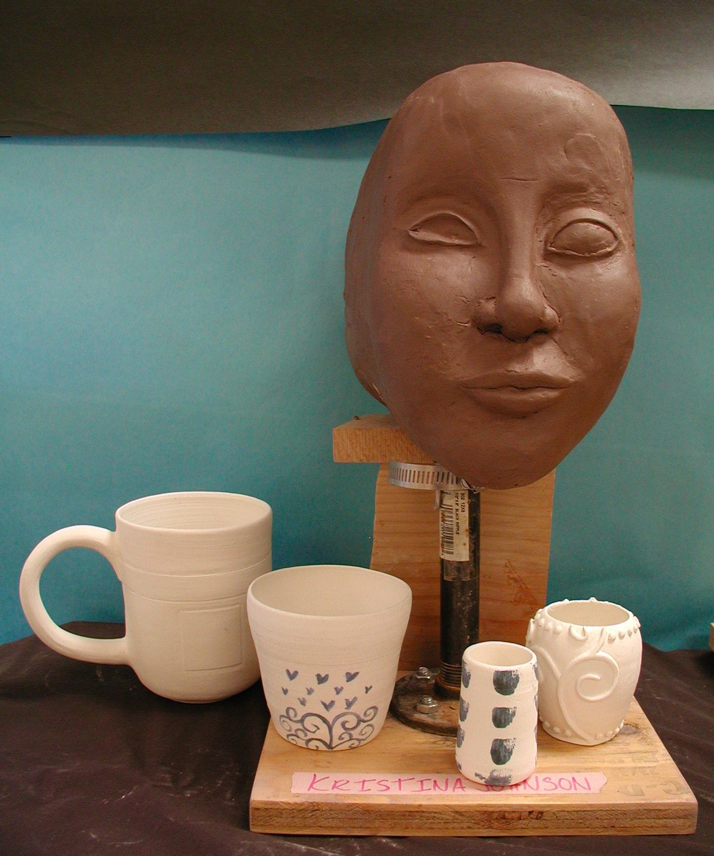 This collection of student works shows development of throwing skills and a self portrait bust in process.
