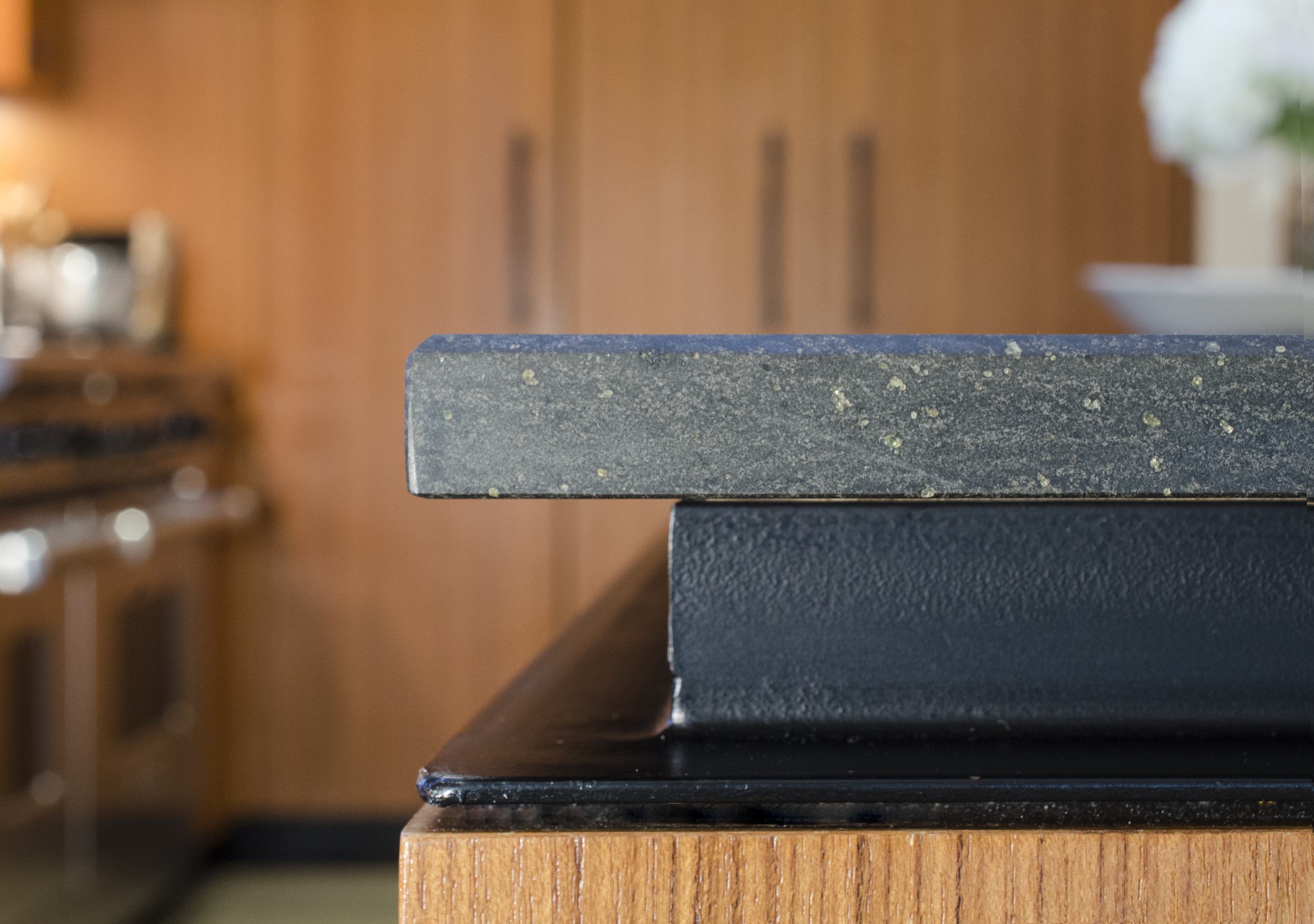 Kitchen counter edge detail: Matte black basalt stone, elevated on a custom fabricated steel reveal.