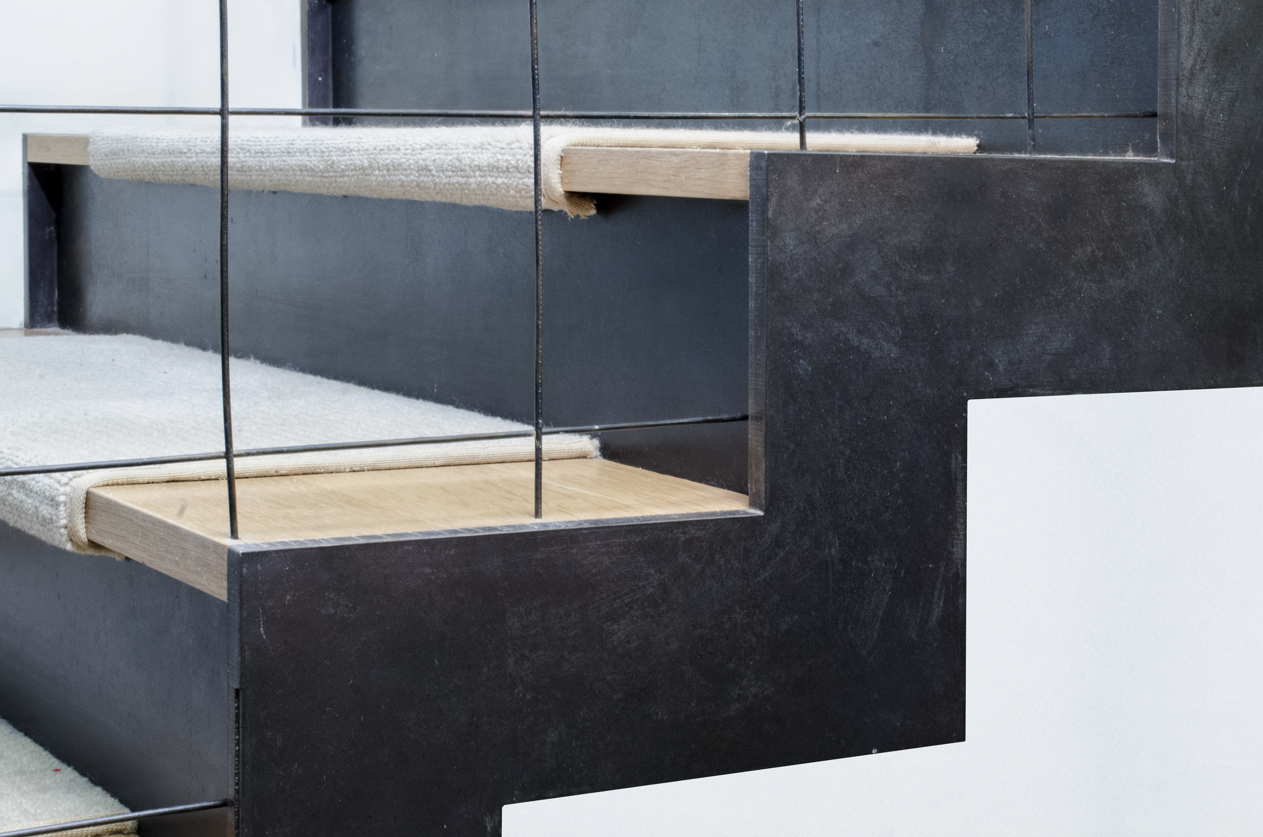 Basement staircase detail: Half inch thick steel plate, water-jet cut and assembled with quarter sawn white oak treads, and a woven steel wire mesh railing.