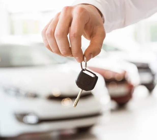 Car dealer handing over keys after obtaining OMVIC dealer licence in Ontario
