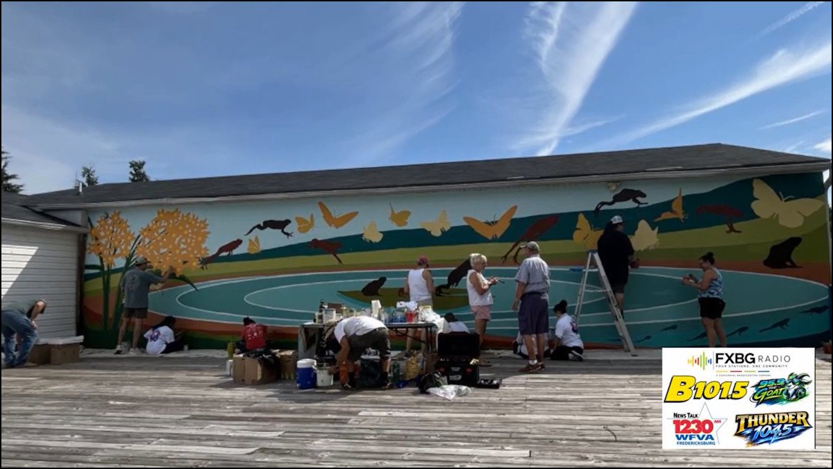 YouTube still of a group of people working on a mural.