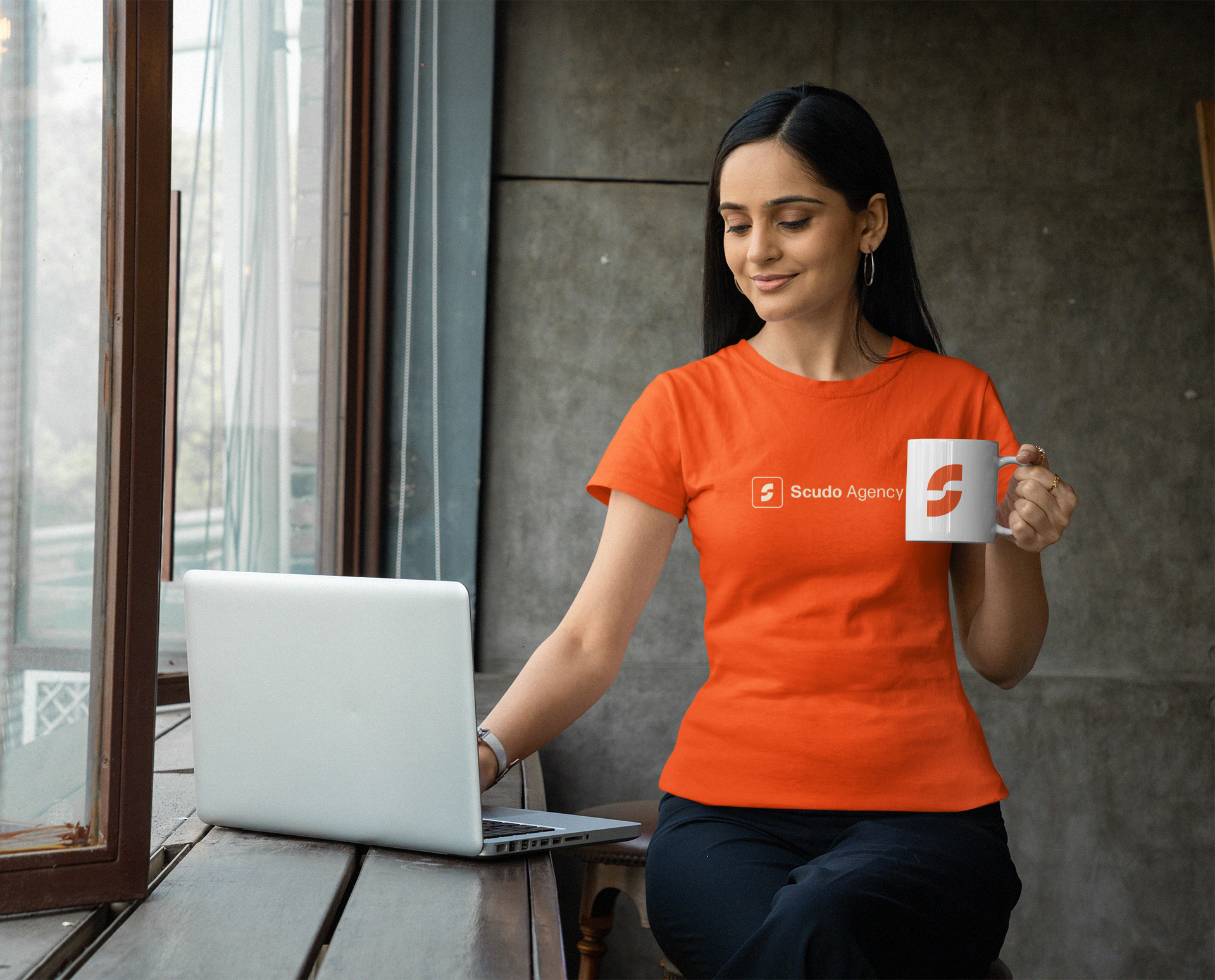 gildan-tee-mockup-of-a-woman-using-her-laptop-and-holding-an-11-oz-coffee-mug-m31776.png