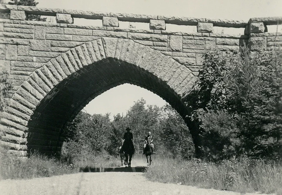 Horseback riders pass under Eagle Lake Bridge in Acadia National Park
