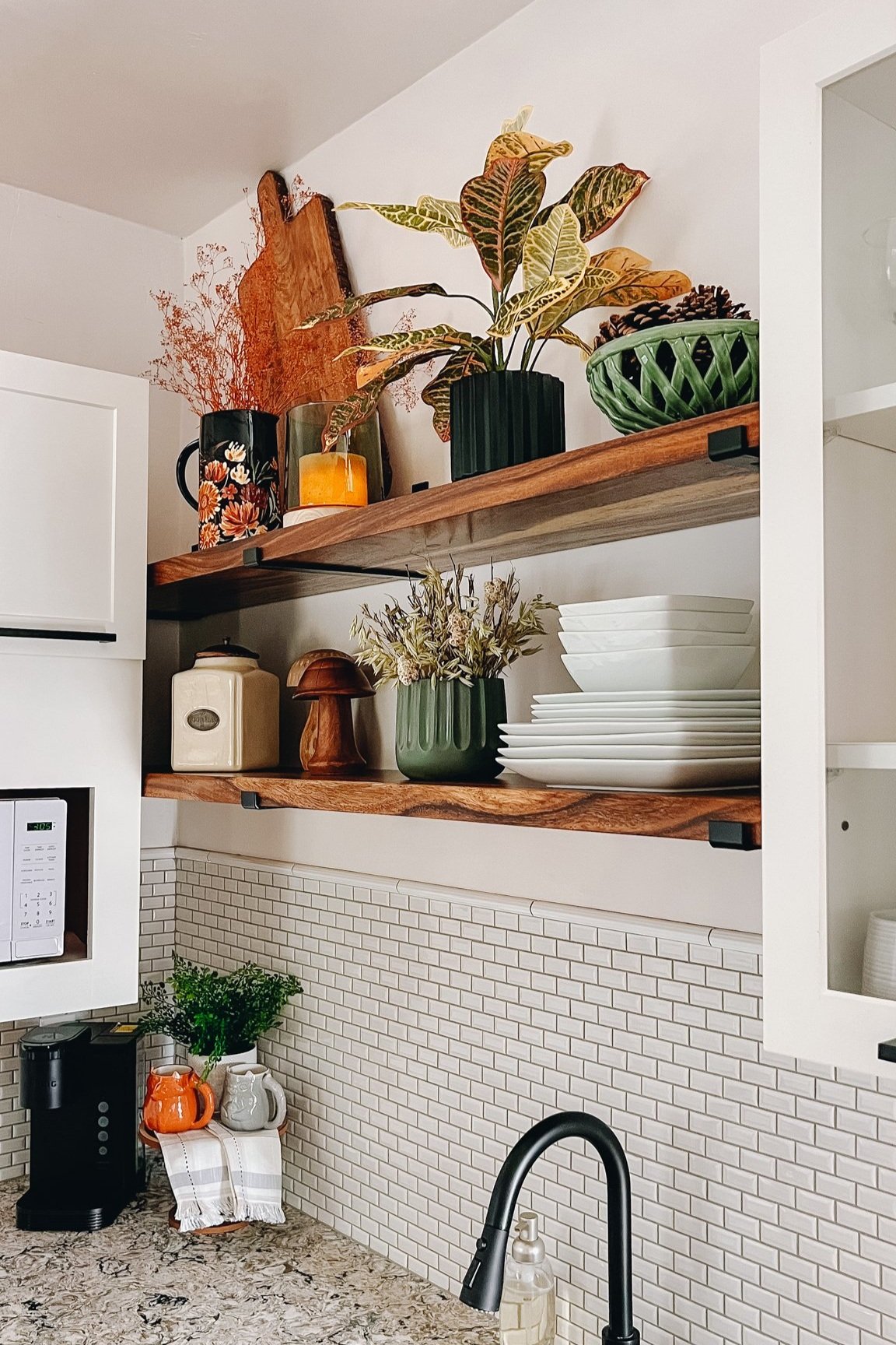 wooden floating shelves in a white kitchen with woodsy decor