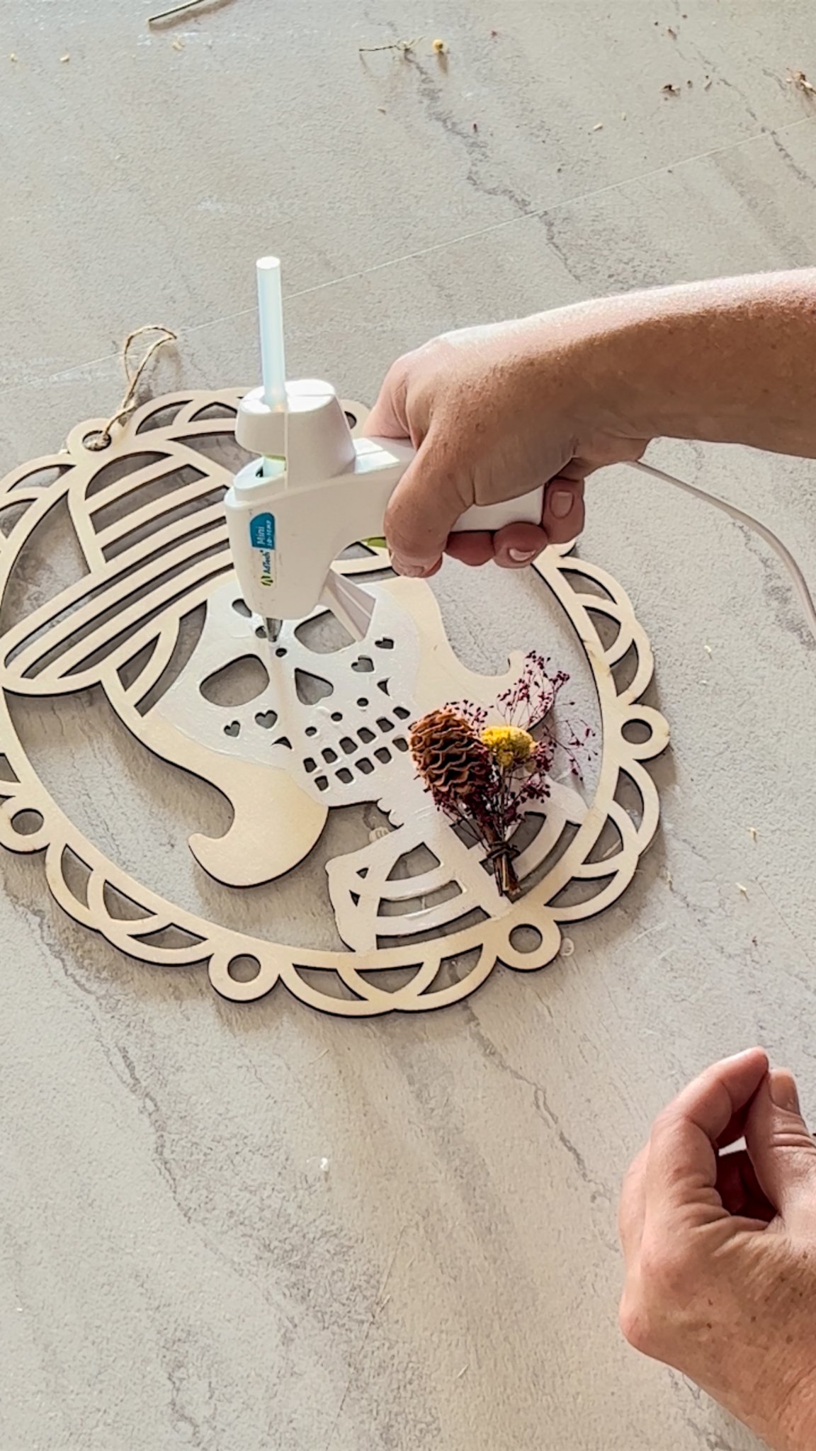 gluing dried naturals onto calavera wreath for dia de los muertos