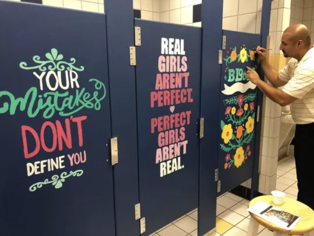 From Article: Principal Garcia adds finishing touches to one of the bathroom stalls. (Photo: Courtesy Warren Middle School Forney ISD)