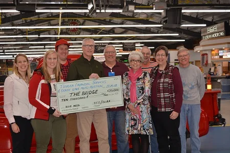 (left to right): State LIne Auto Auction owners Beth Barber, Emily Barber and Paul Barber; and Bob Brooks, TFS Regional Remarketing Manager-Eastern Region, present a check for $10,000 to personnel from The Bridge.
