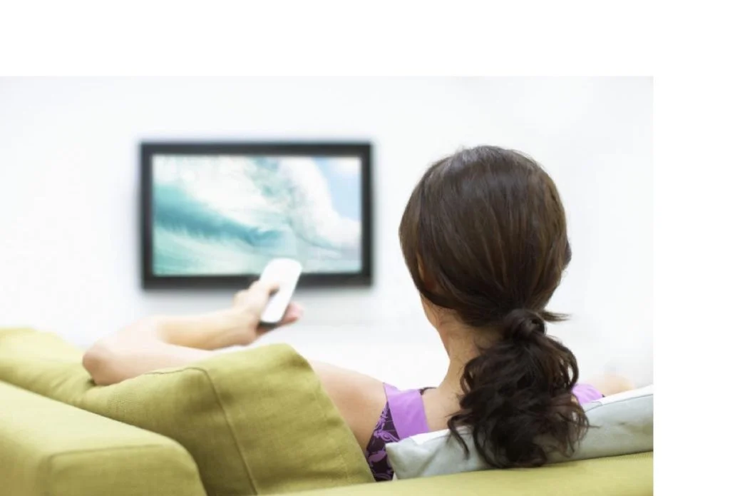 Young woman watching television, rear view