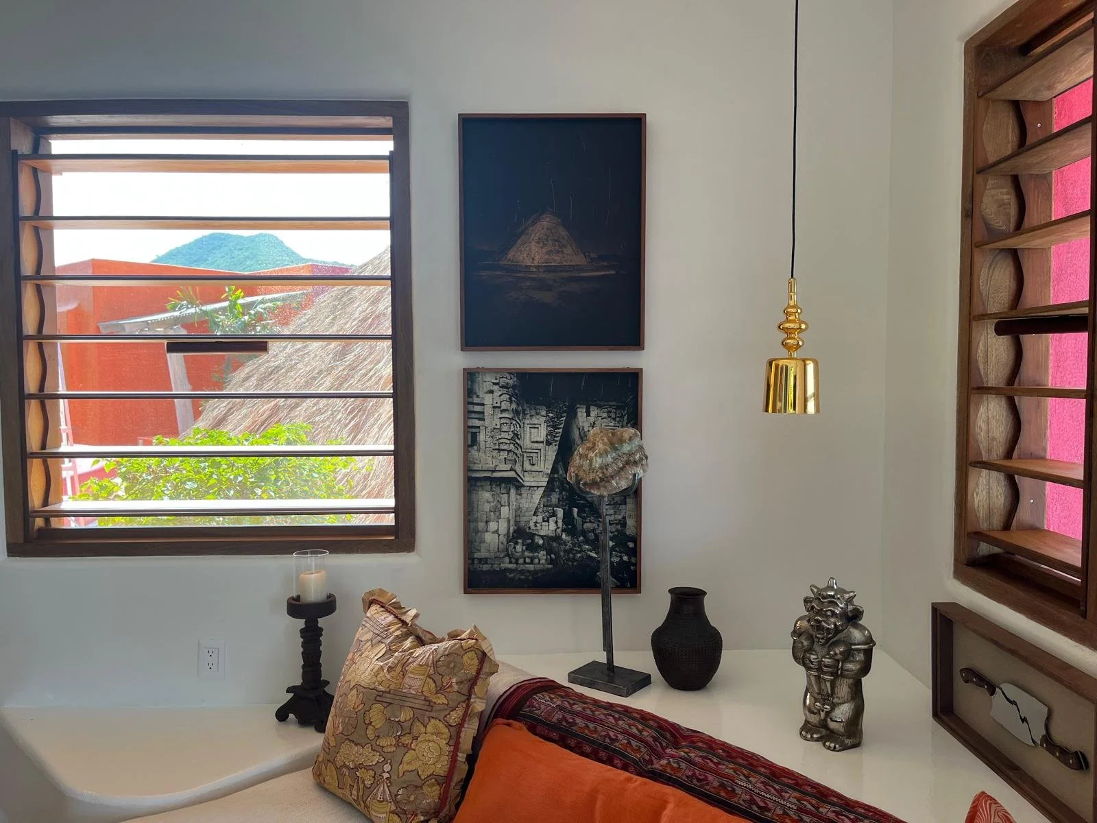Art wall with framed photographs and collected sculptures in the Sun suite, Casa Papelillo, interiors by Amathea