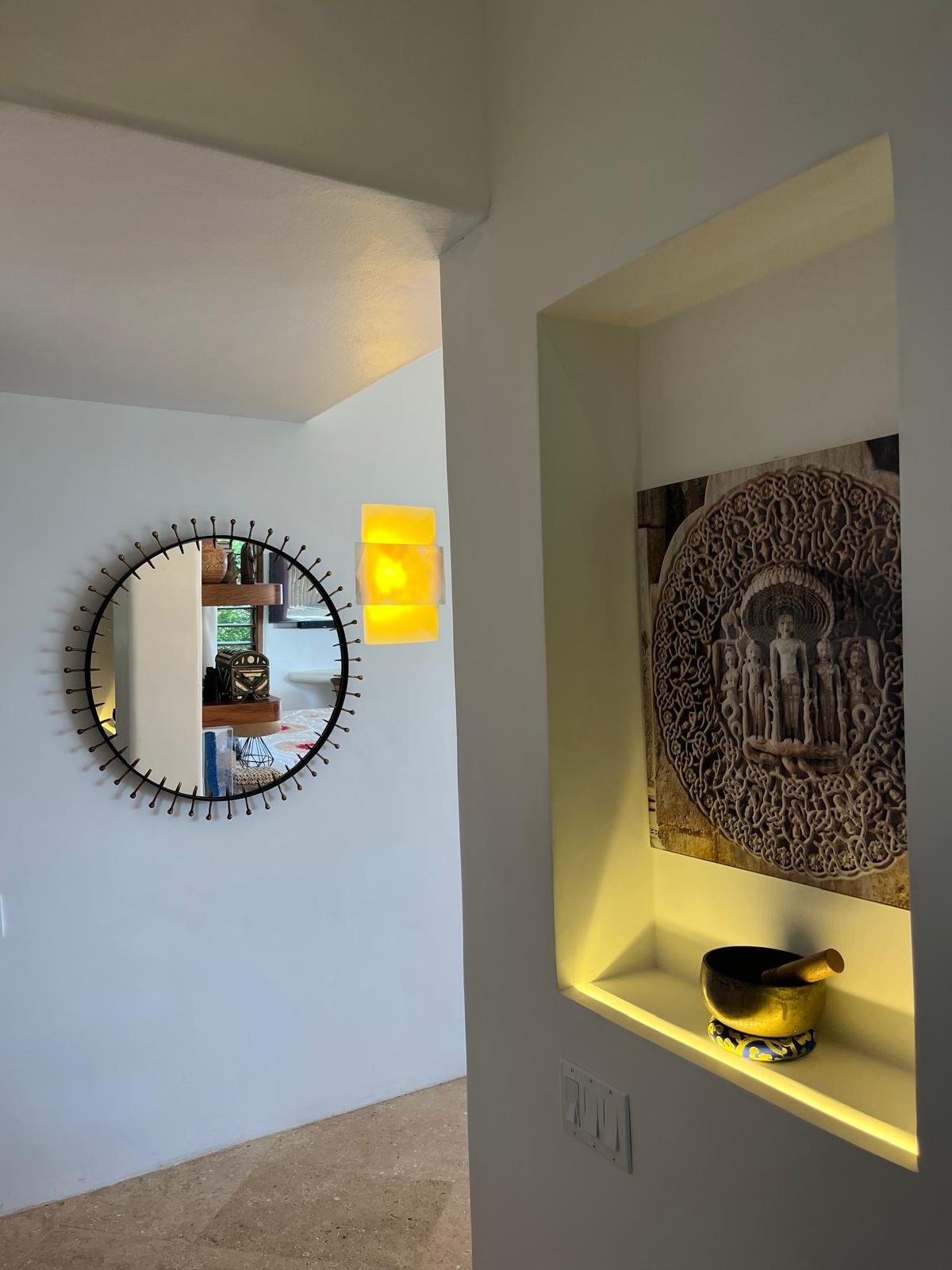 Lit wall niche with a brass singing bowl and carved panel, Casa Papelillo, interiors by Amathea