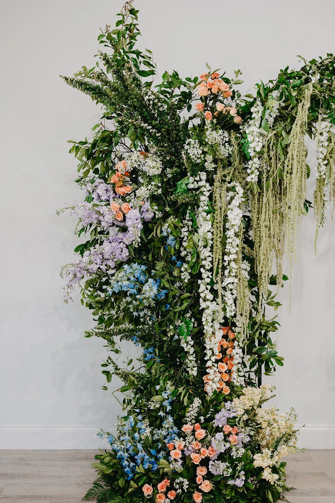 Garden-inspired floral arch with amaranthus and pastel floral arrangements in purple, blue, orange, and white tones, designed by Bluegrass Chic, an Orlando event florist.