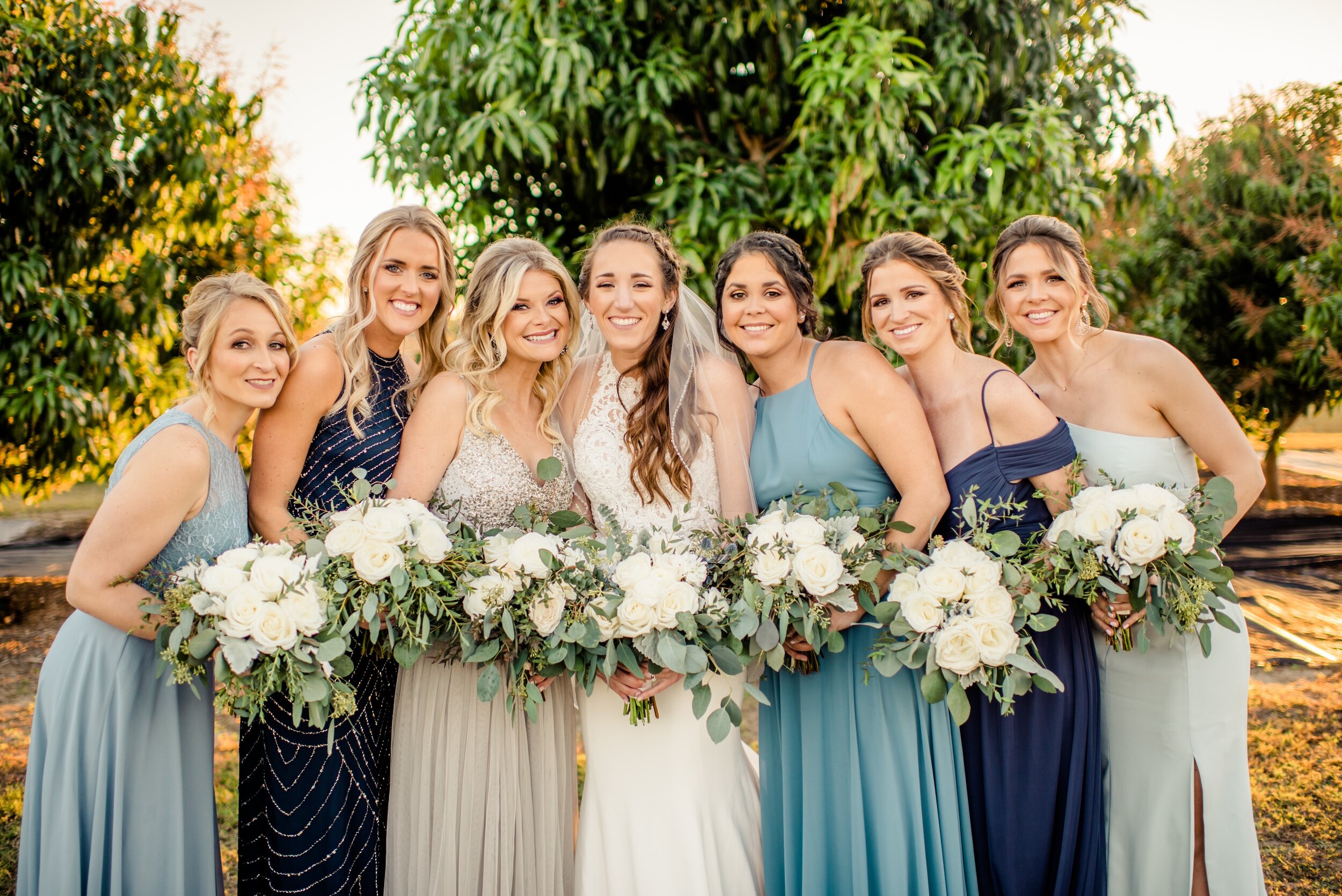 The bridesmaid in shades of blue with simple white and green eucalyptus bouquets
