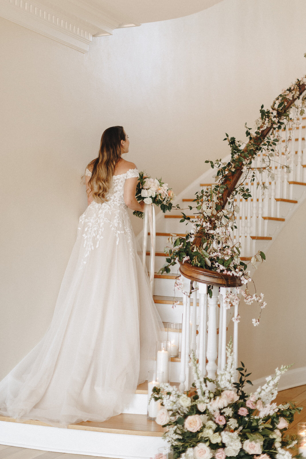 Bridal Portrait on Staircase with Garden Style Greens going up the stairs and a romantic candle set (Copy) (Copy)