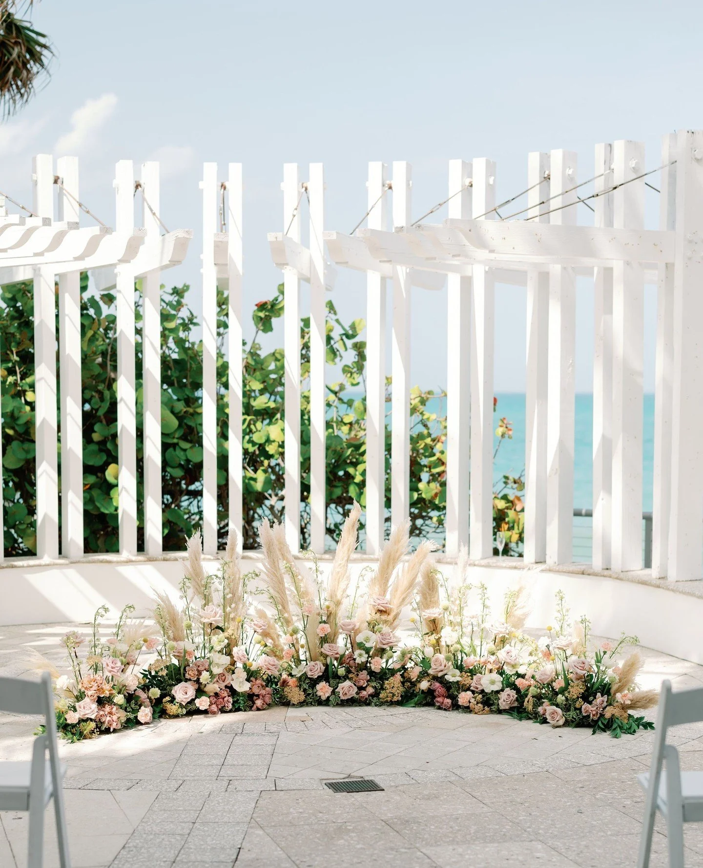a seaside ceremony🐚🌞 Swipe for gorgeousness!!⁠
⁠
Ellen and Bryan's sweet ceremony was filled with beautiful blooms, soft pampas grass, and the calming sound of the ocean! It can't get better than that!⁠
⁠
Are you looking for a beautiful soft ceremo