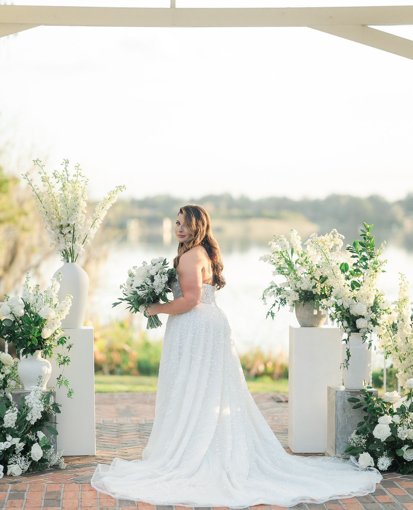 floral collection of your DREAMS!🌿🕊️ Swipe to see this stunning ceremony setup at @cypressgroveestatehouse⁠
⁠
Instead of a traditional arch, Courtney wanted an elegant collection of floral surrounding them for their I DOs! Columns, pots, and vases 