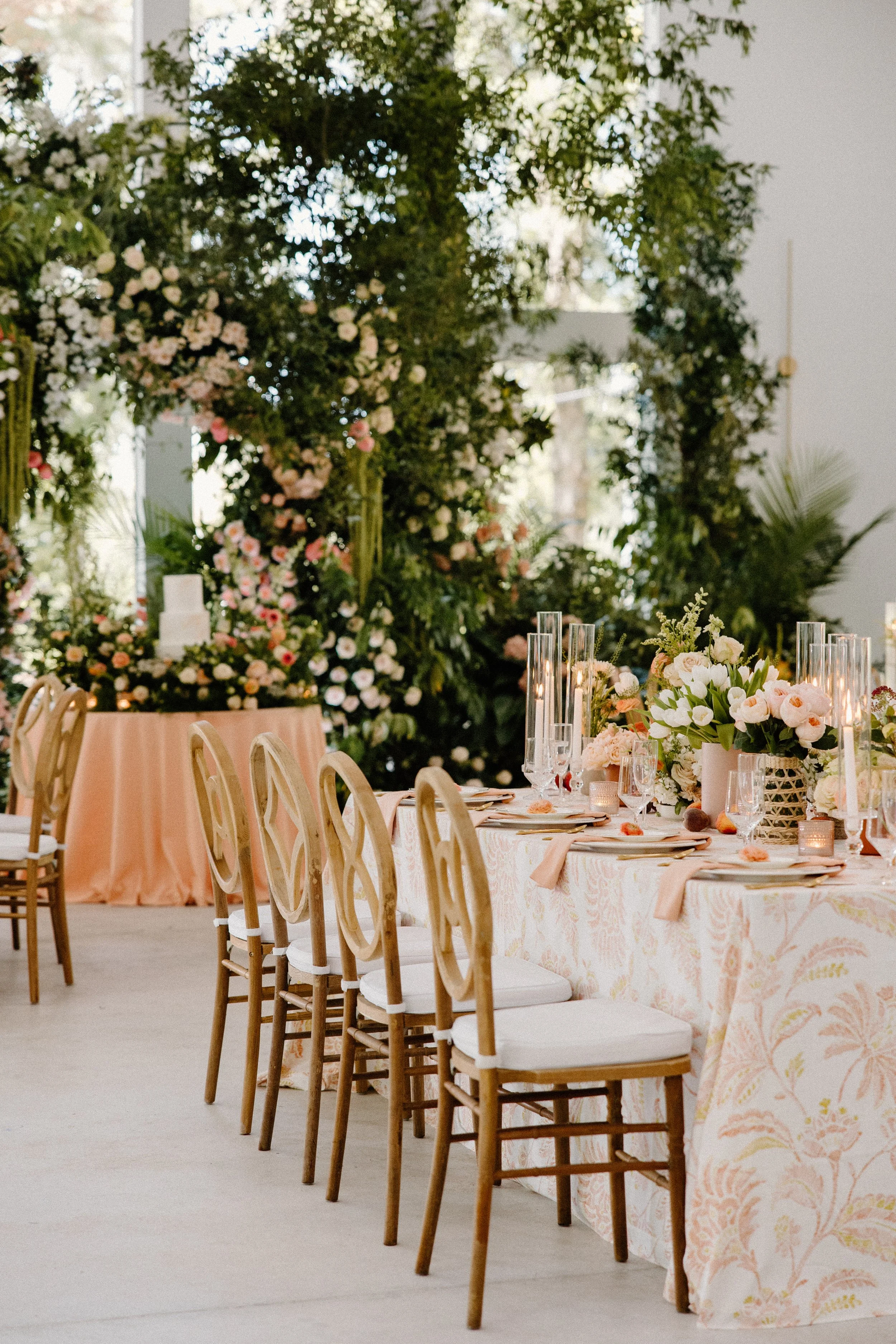 Alt Text: Large lush peach floral arch framing a Whitewood Ranch wedding ceremony, designed by Bluegrass Chic, an Orlando wedding florist.