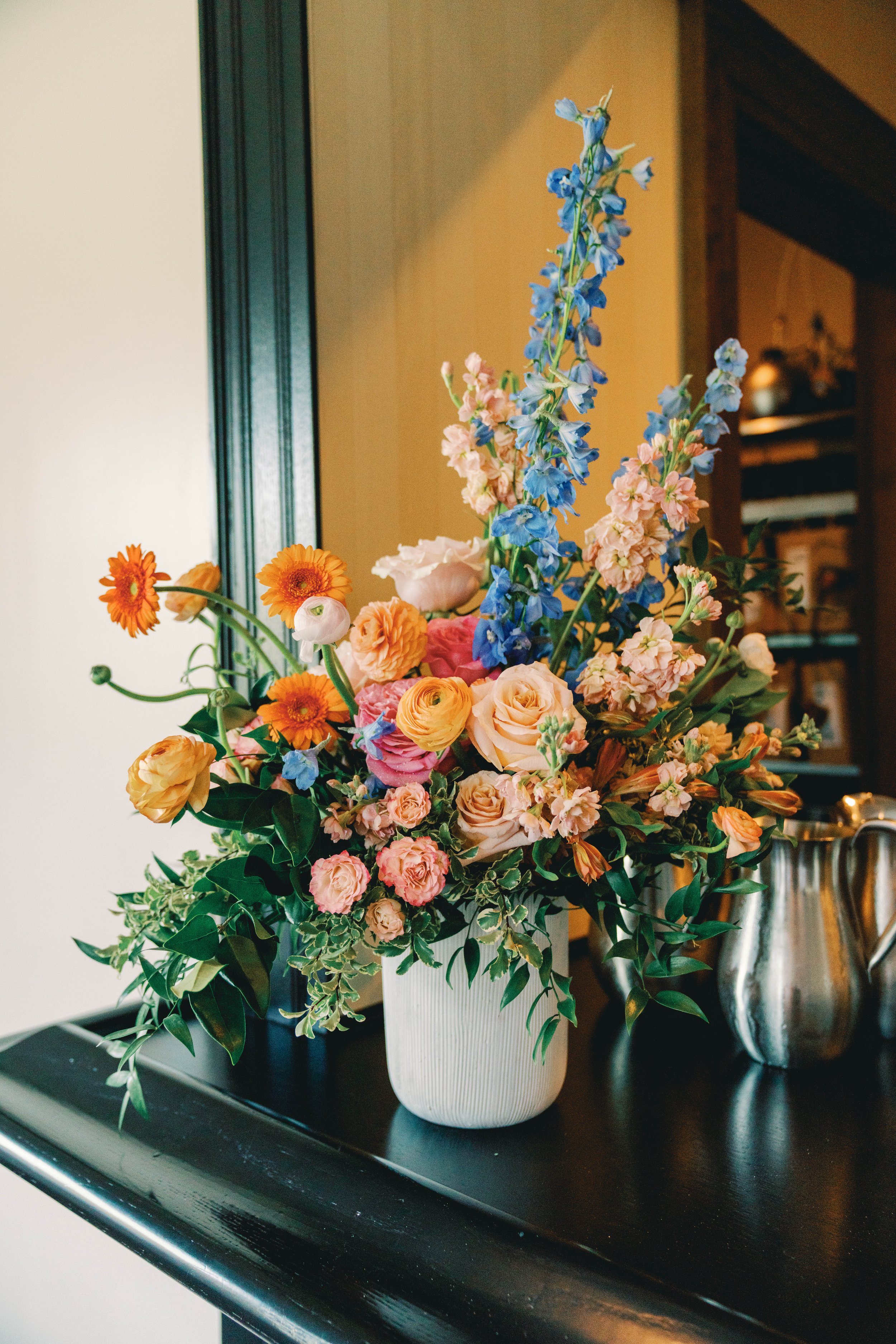 Bright summer floral design featuring peach blooms on an event bar, designed by Bluegrass Chic, an Orlando event florist.
