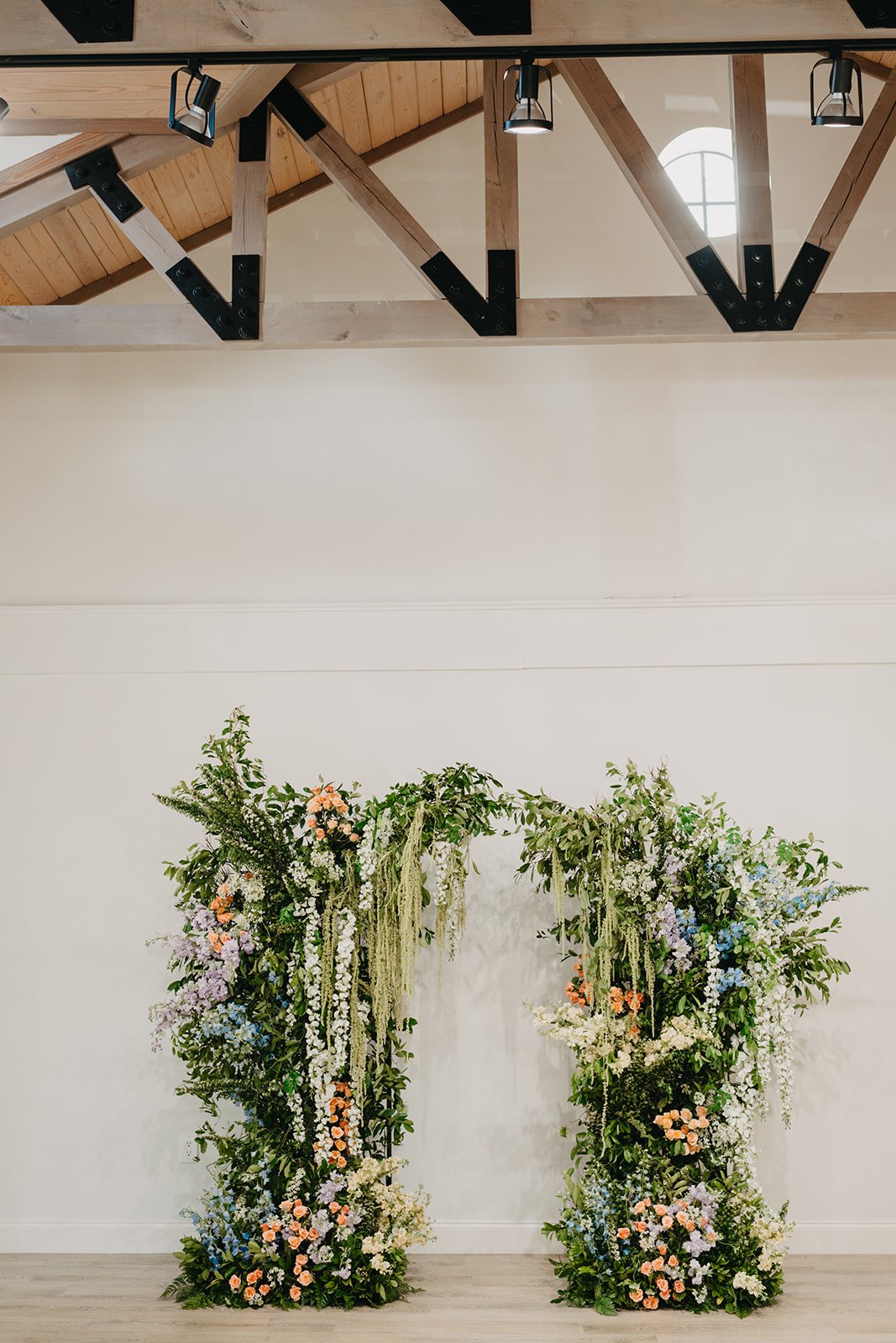 Garden-inspired floral arch with amaranthus and pastel floral arrangements in purple, blue, orange, and white tones, designed by Bluegrass Chic, an Orlando event florist.