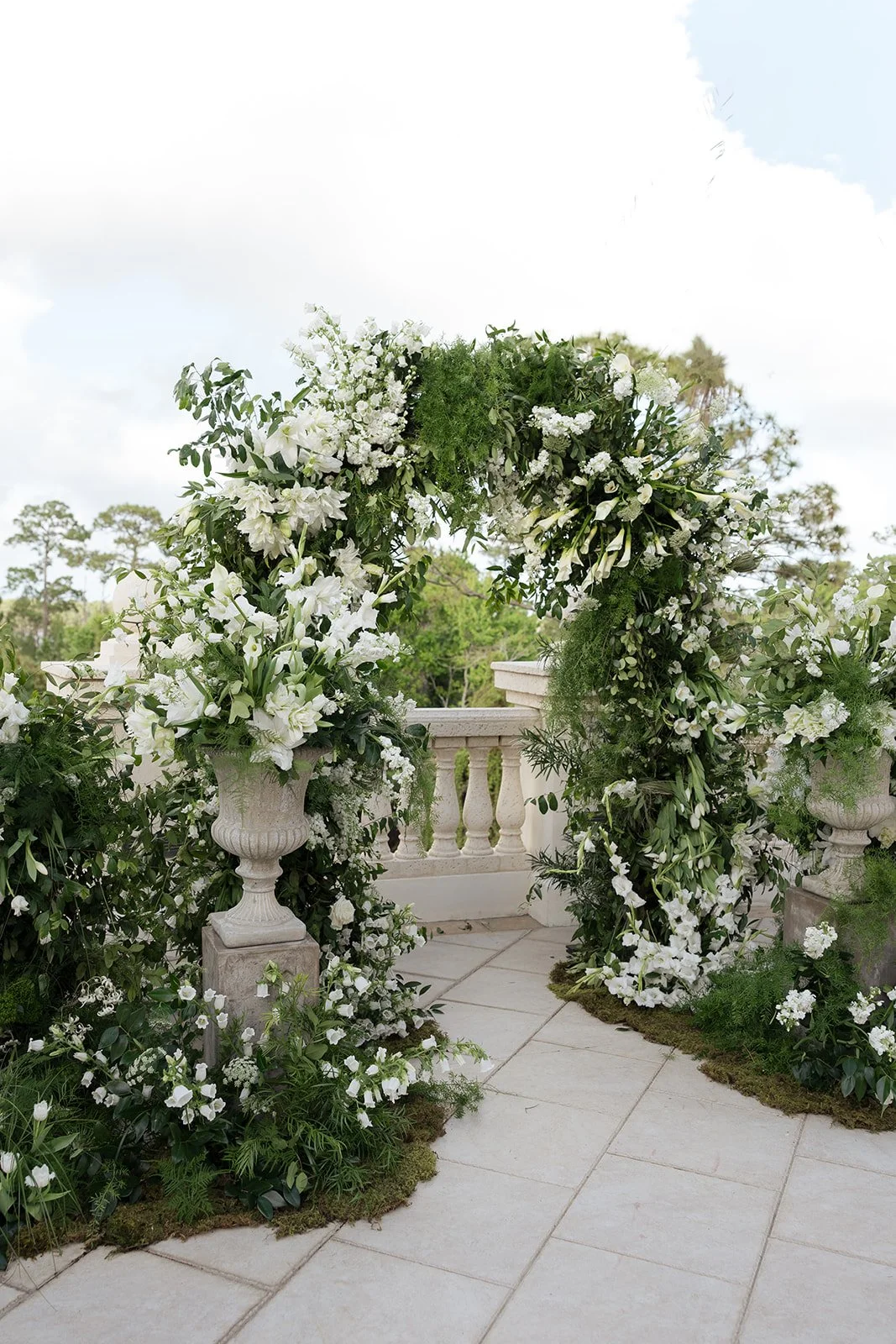 Overgrown white floral wedding arch with calla lilies, tulips, grasses, and airy greenery at Crane Club, designed by Bluegrass Chic.