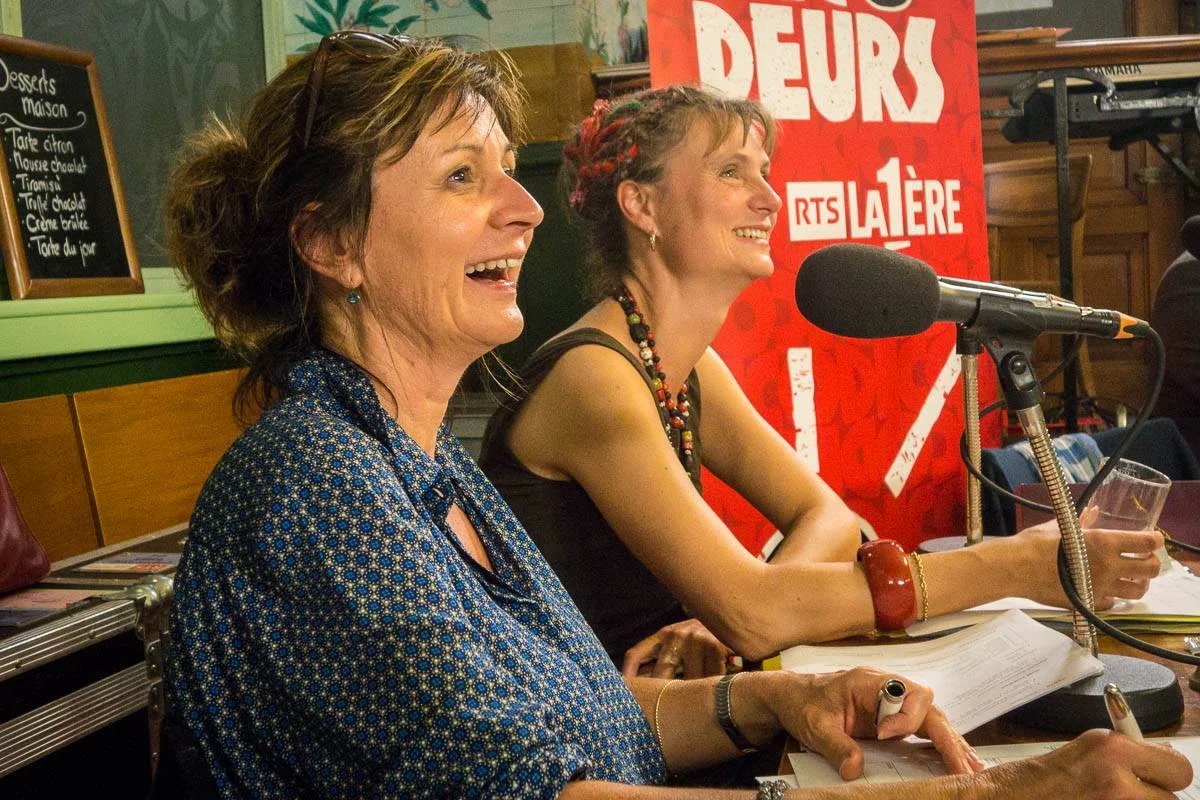 Laurence Bisang et Julie Rieder écoutent la chanson "Elle est d'ailleurs" de Pierre Bachelet, revisitée par les Dicodeurs