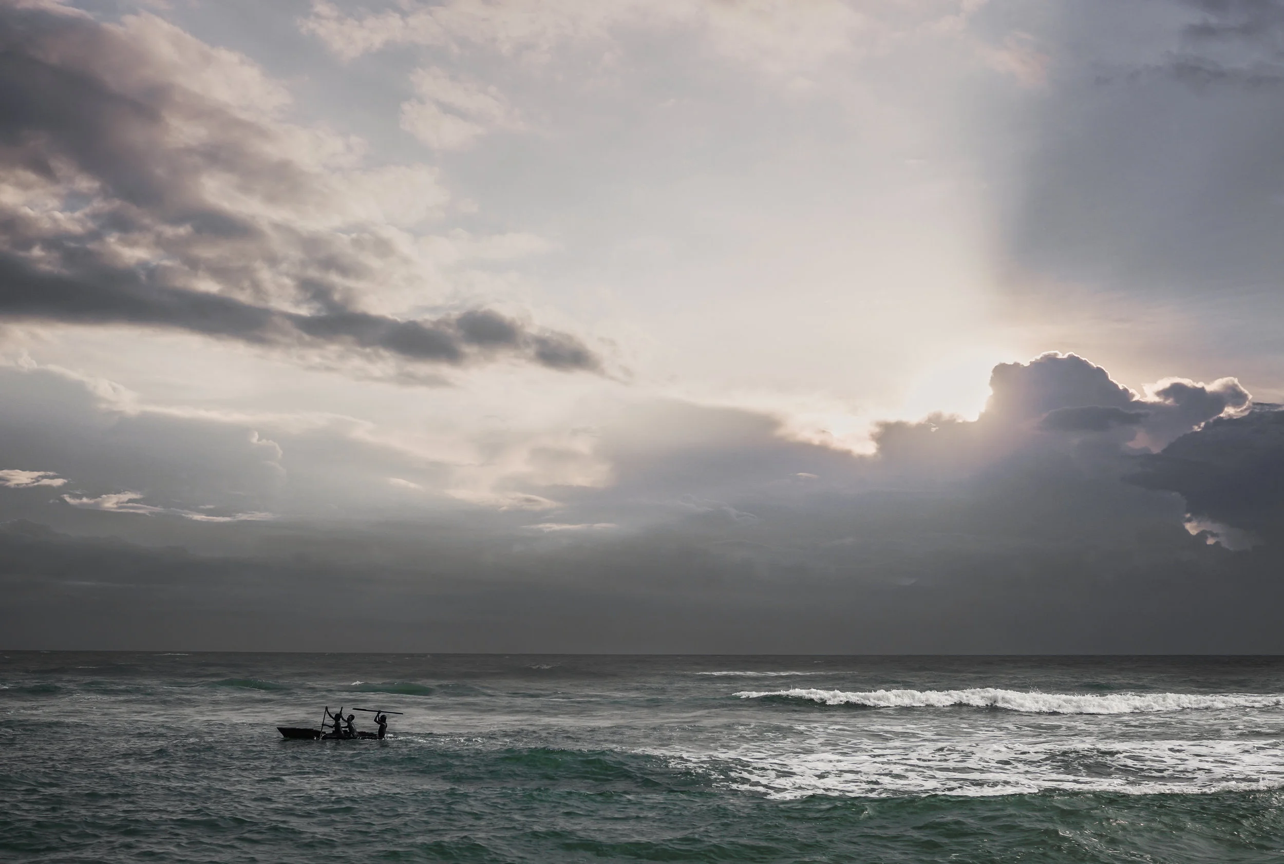  As the sun rises near a fishing village in cape coast, a father and his two sons courageously set sail in strong currents. 