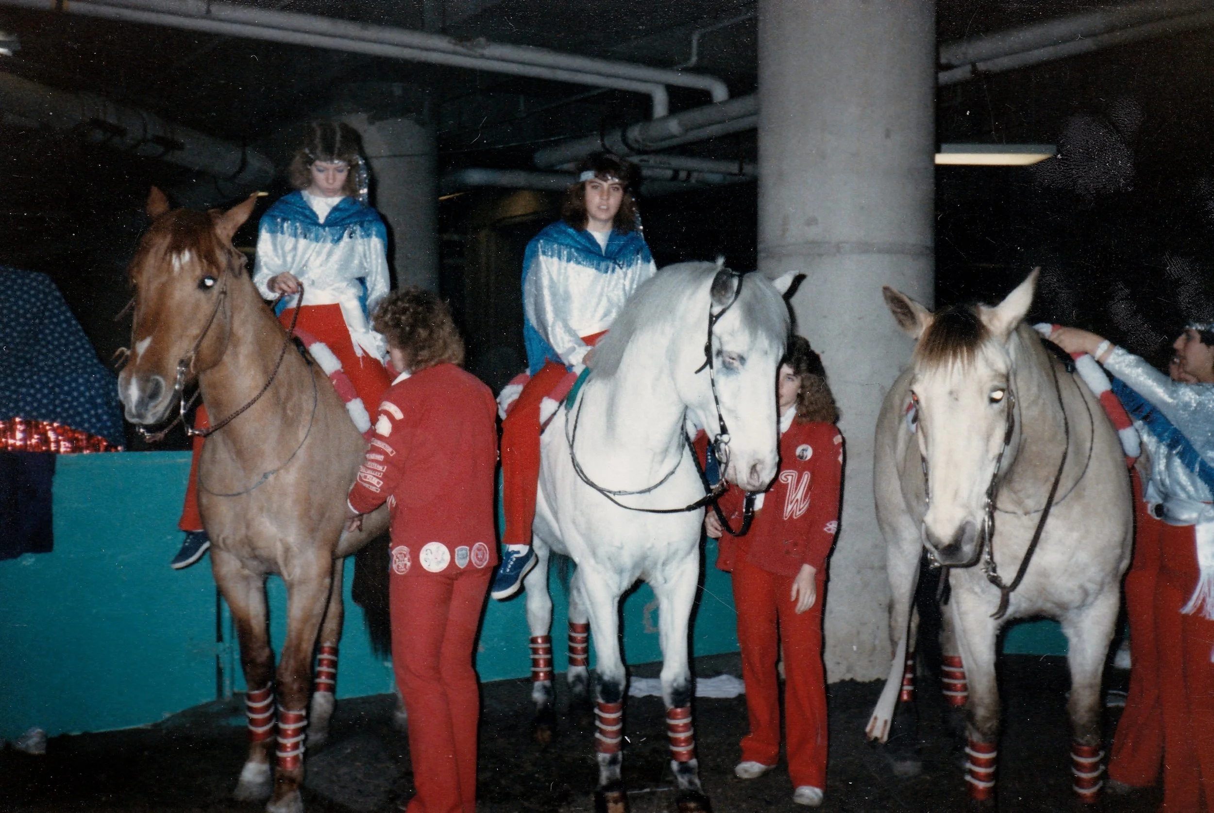 Liberty Riders get costume change help from their teammates. Left to right: Marcia Rydgren (mounted), Carla Kaisen (on ground), Chris Padilla (mounted), Shelley Underwood (on ground), Nicole Mezo (just about to mount up).