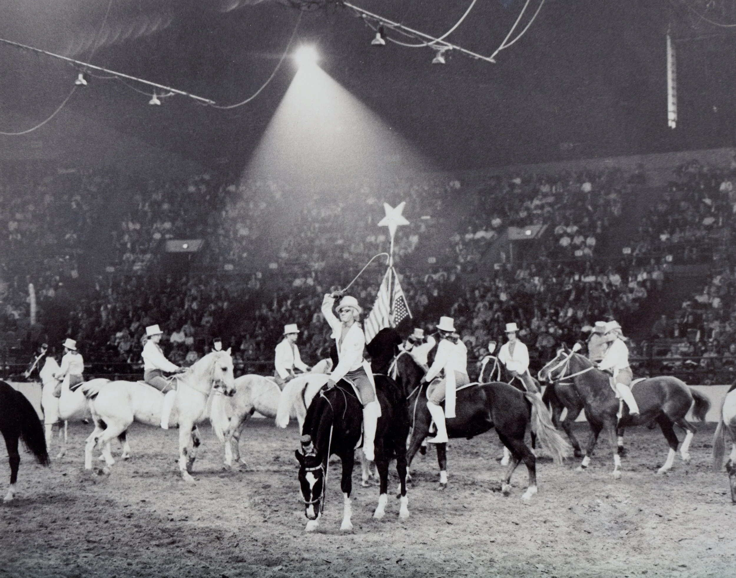 Melodie Mundell salutes the National Western Stock Show crowd during the 1969 exhibition of the dressage riders of Westernaires.